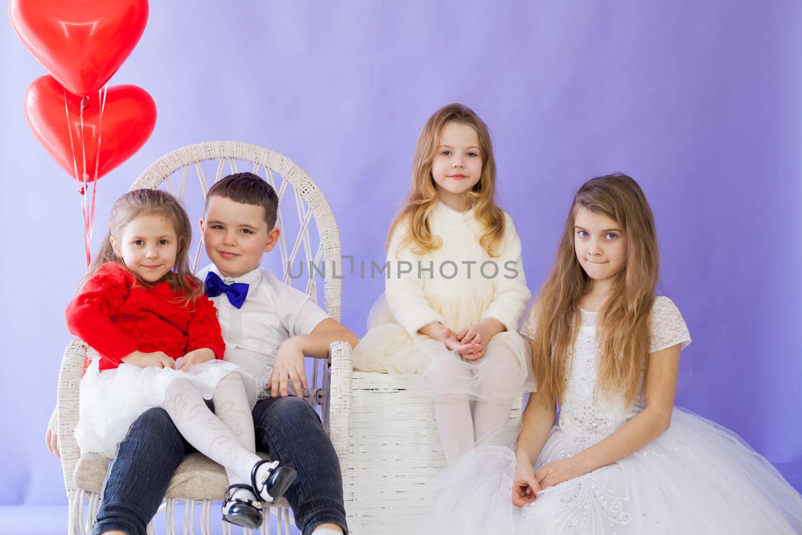 Boy and girls with red heart-shaped balloons on birthday