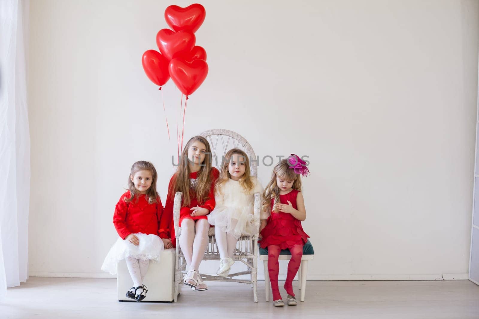 Girls with red heart-shaped balloons on birthday party by Simakov
