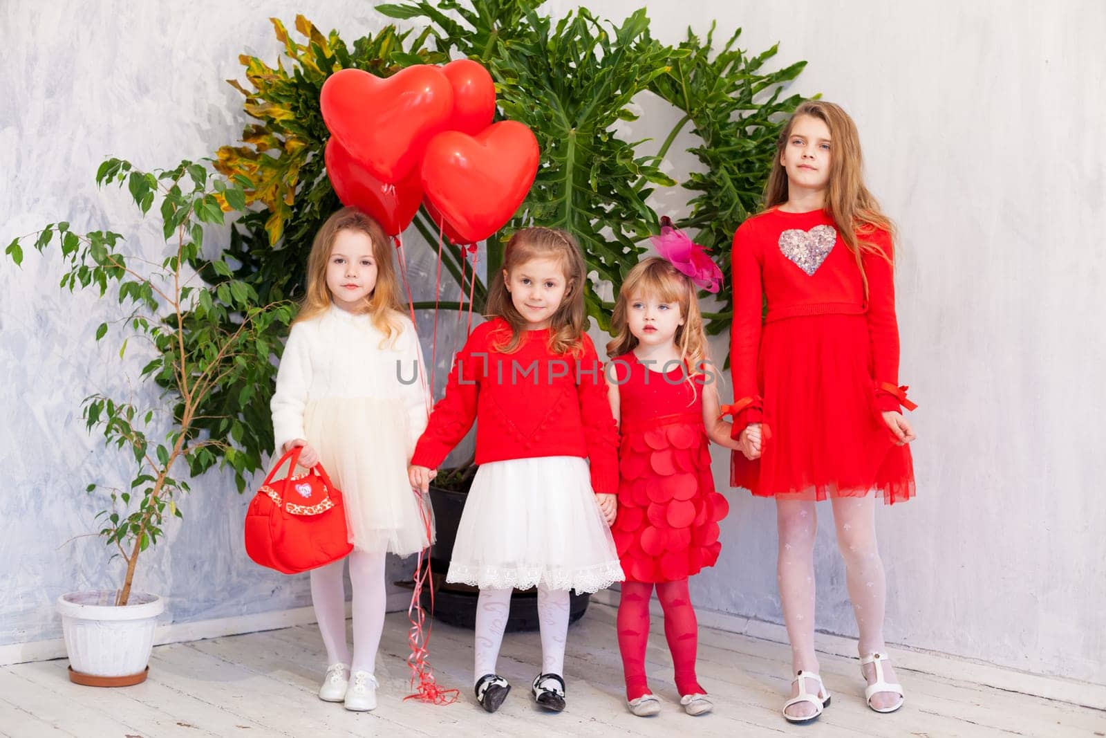 Girls with red heart-shaped balloons on birthday party by Simakov