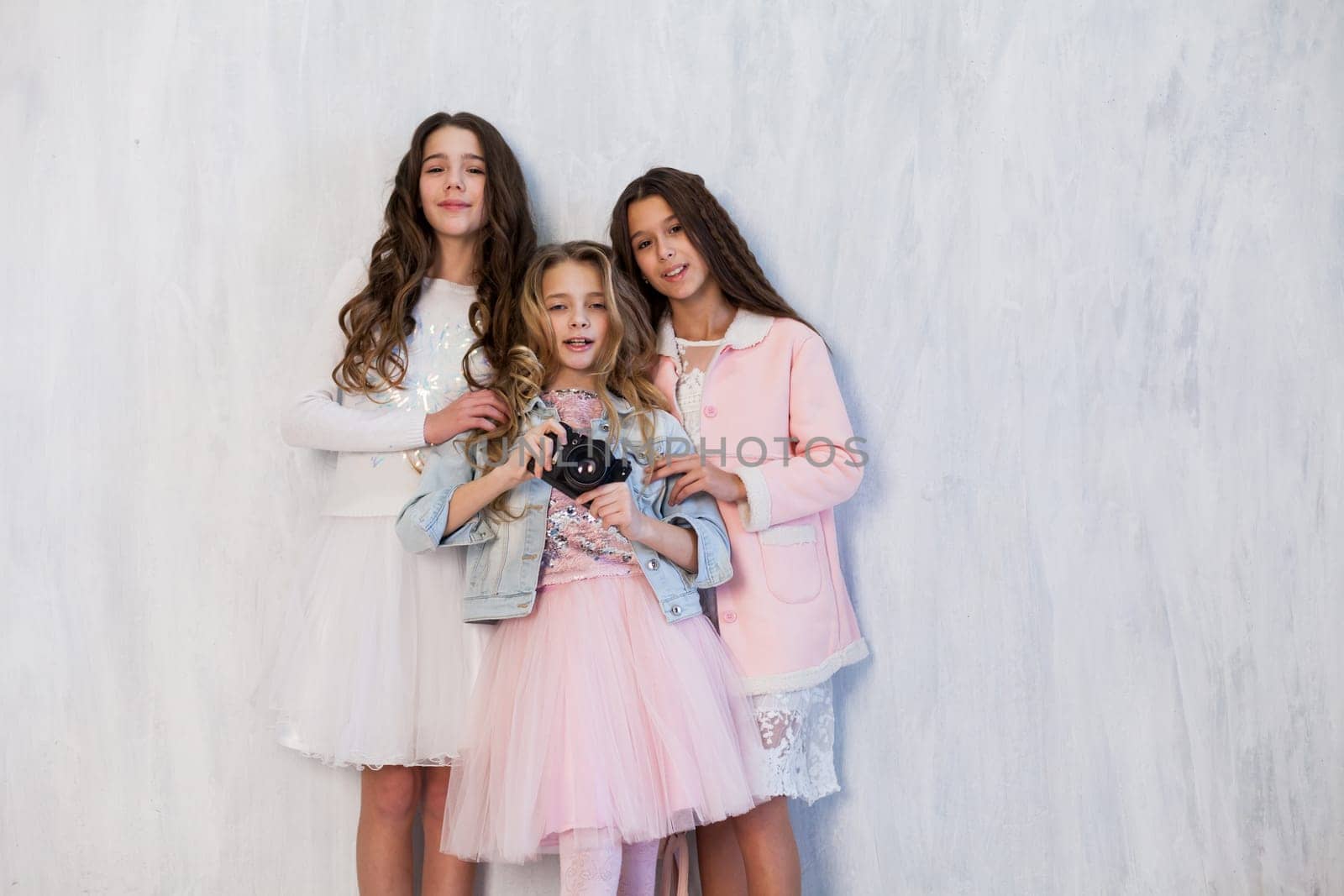Three beautiful fashionable girl girlfriends in white pink dresses by Simakov