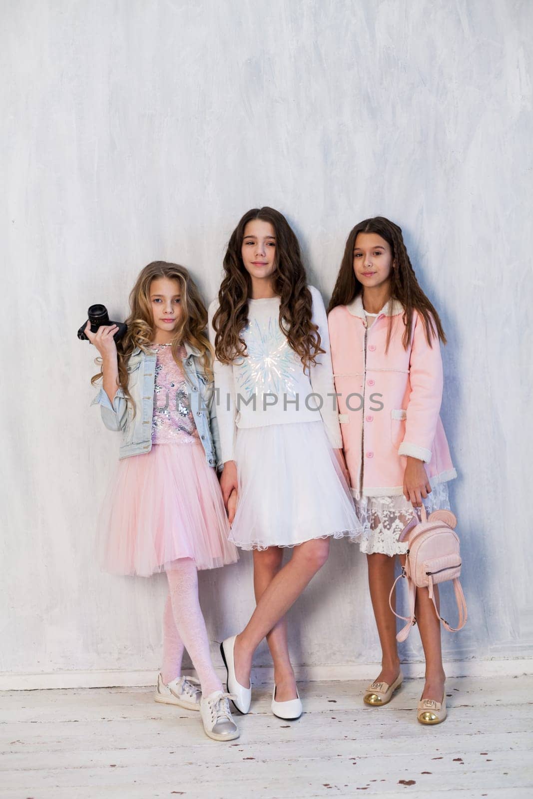 Three beautiful fashionable girl girlfriends in white pink dresses by Simakov