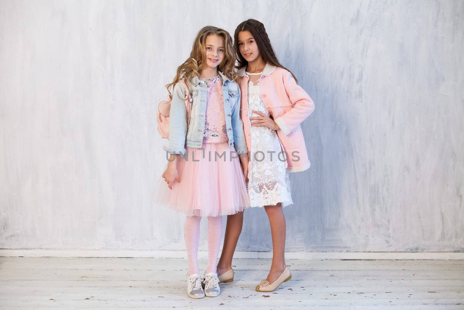 Two beautiful fashionable girl girlfriends in white pink dresses by Simakov