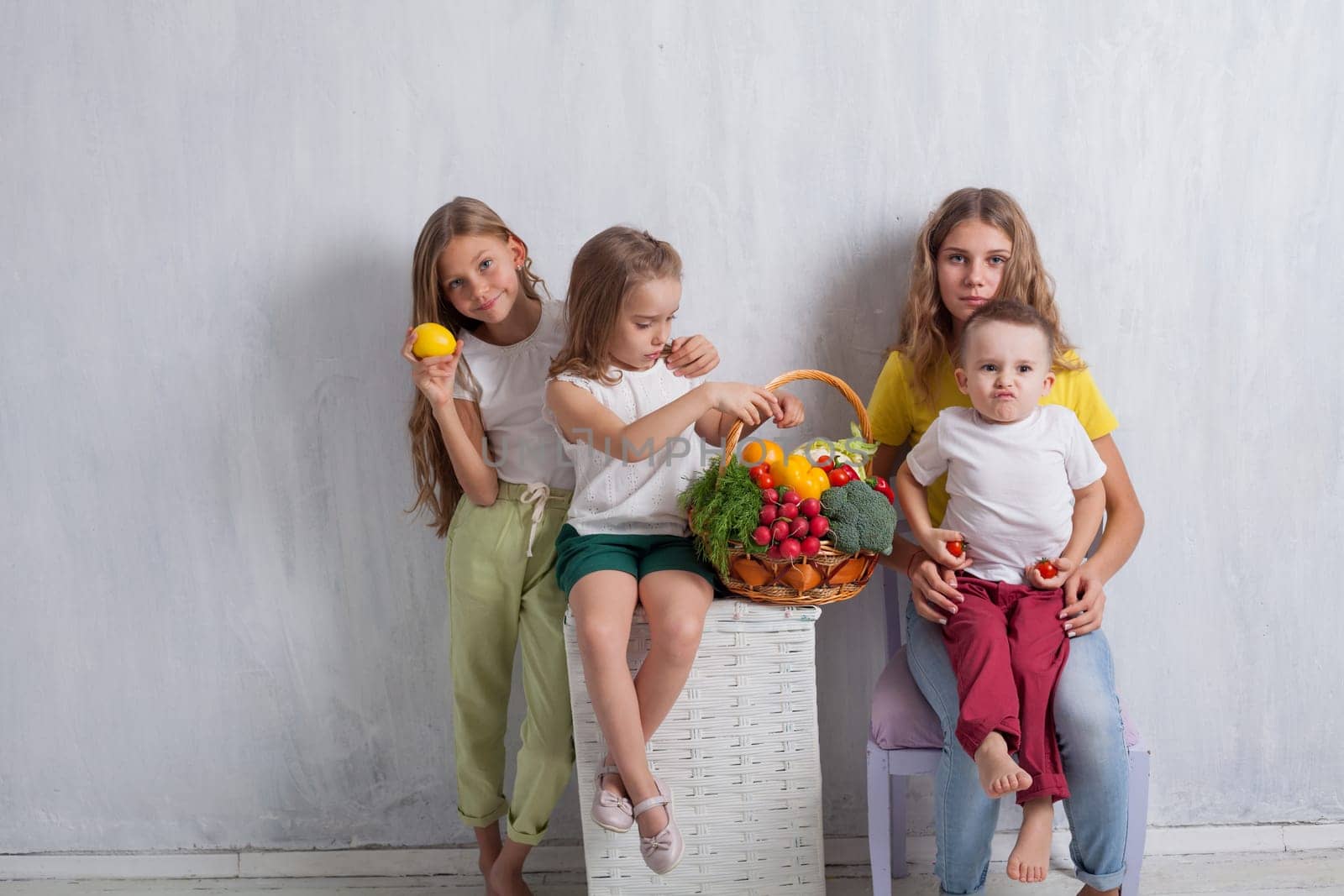 three girls and a boy with a meal of ripe vegetables and fruits