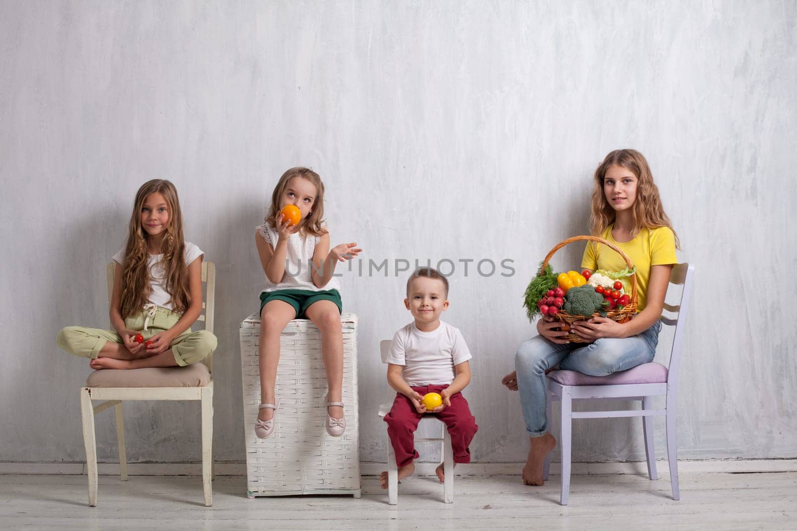 three girls and a boy with a meal of ripe vegetables and fruits