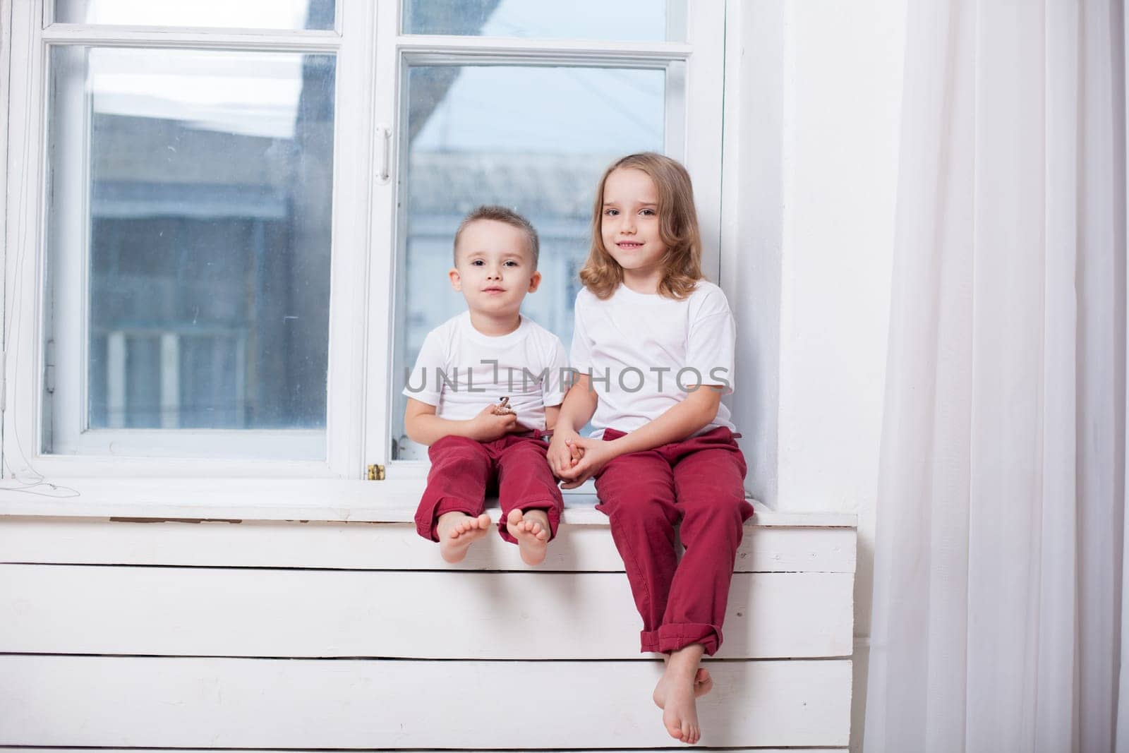 Boy and girl sit together and hold hands by Simakov