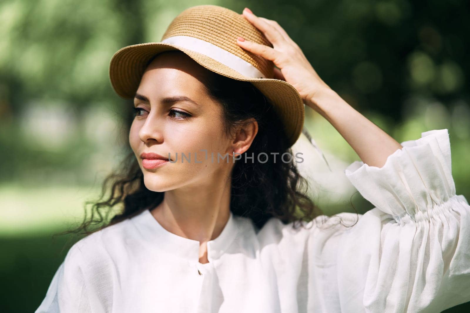Young beautiful girl in a hat in a summer park by driver-s