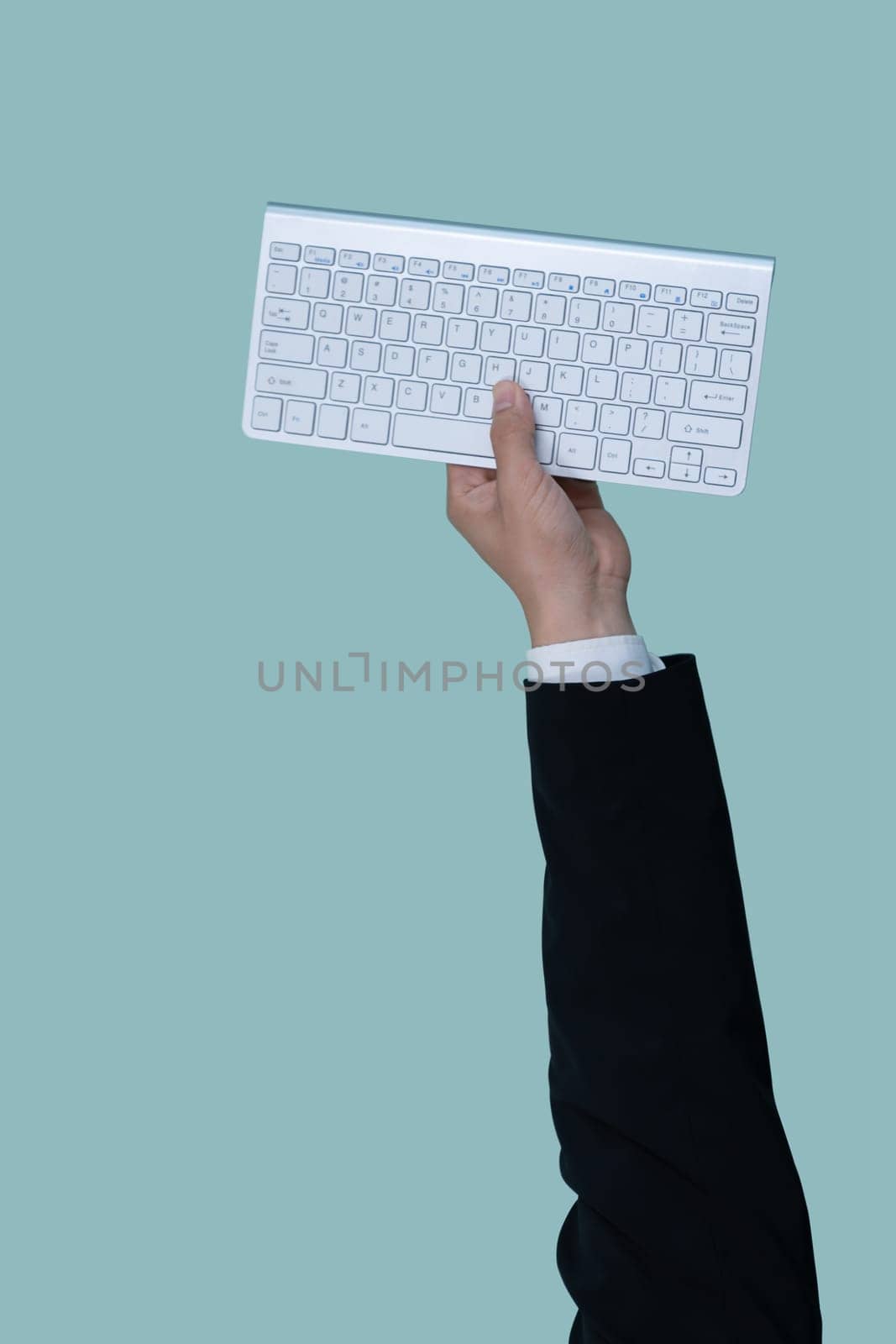 Hand holding wireless keyboard on isolated background for start up tech company. Eco-friendly green business promoting electronic waste policy idea. Quaint