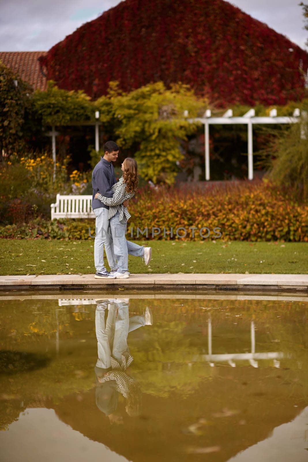 lovely young couple kissing outdoors in autumn. Loving couple walking in nature. Autumn mood. Happy man and woman hugging and kissing in autumn. Love. Fashionable couple outdoors. Fashion, people and lifestyle. Stylish couple in autumn outfit.