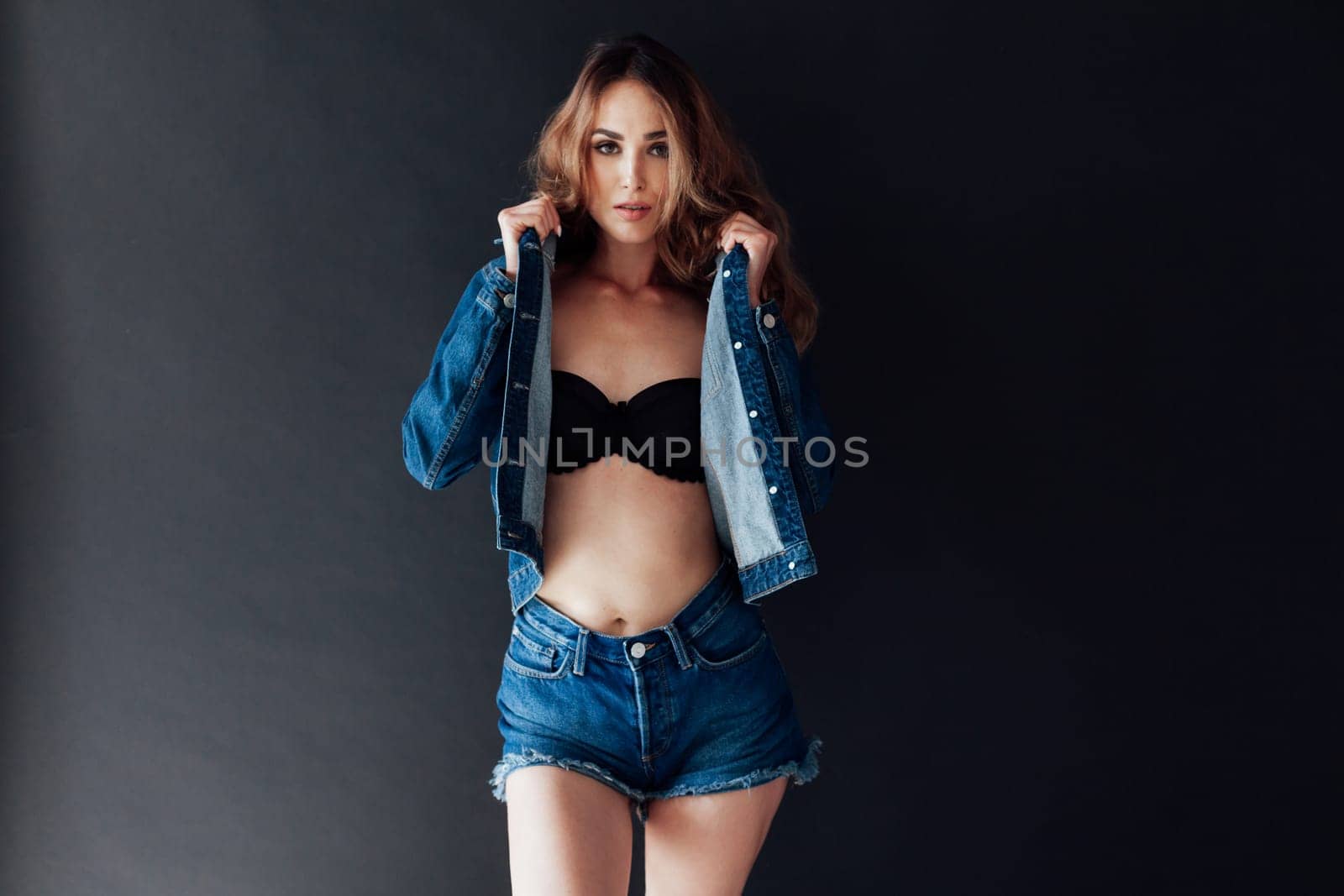 Portrait of a beautiful fashionable woman in lingerie and jeans by Simakov
