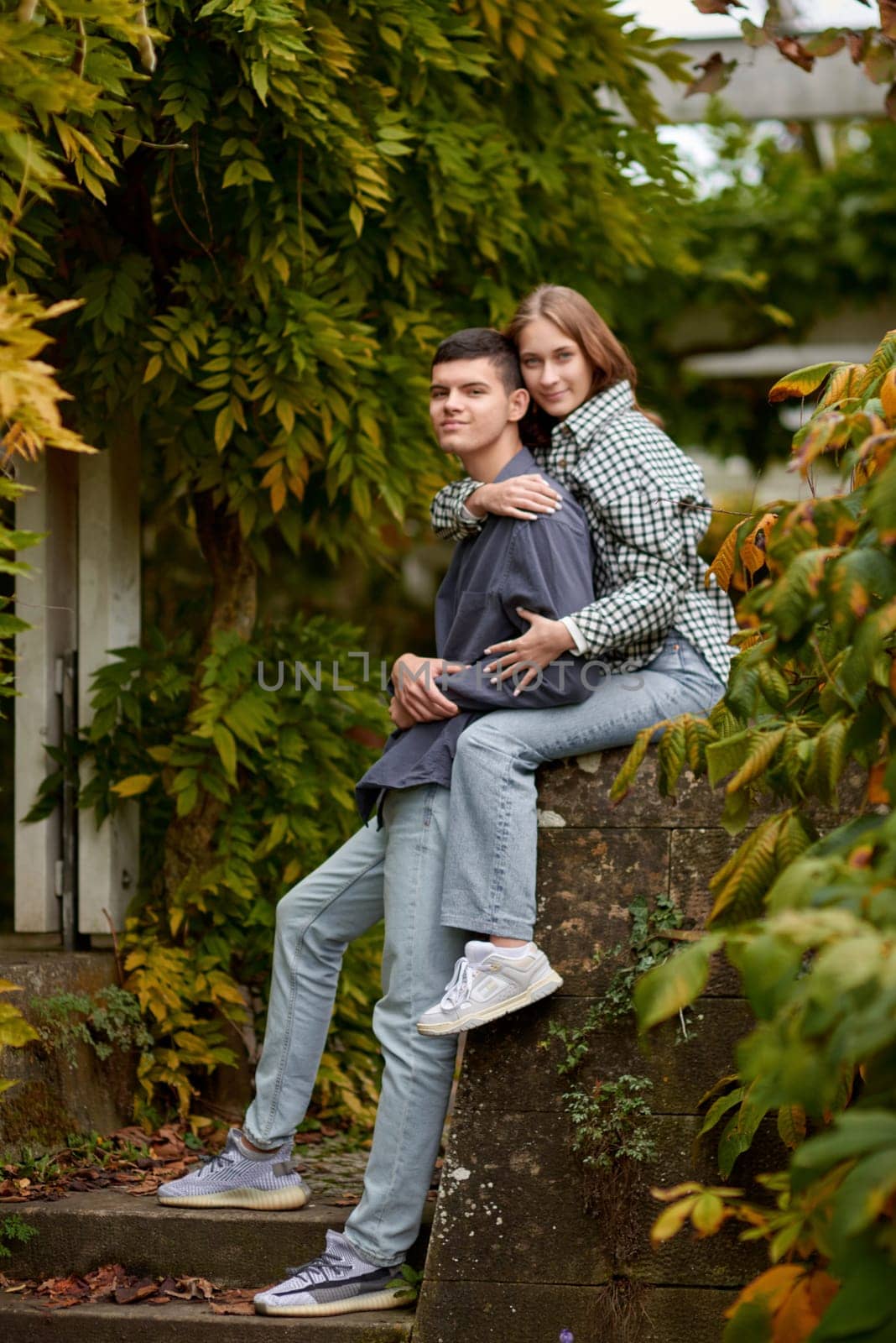 Young Cute Female Hugs Boyfriend. In Autumn Outdoor. Lovers Walking in Park. Attractive Funny Couple. Lovestory in Forest. Man and Woman. Cute Lovers in the Park. Family Concept. Happy Couple. by Andrii_Ko