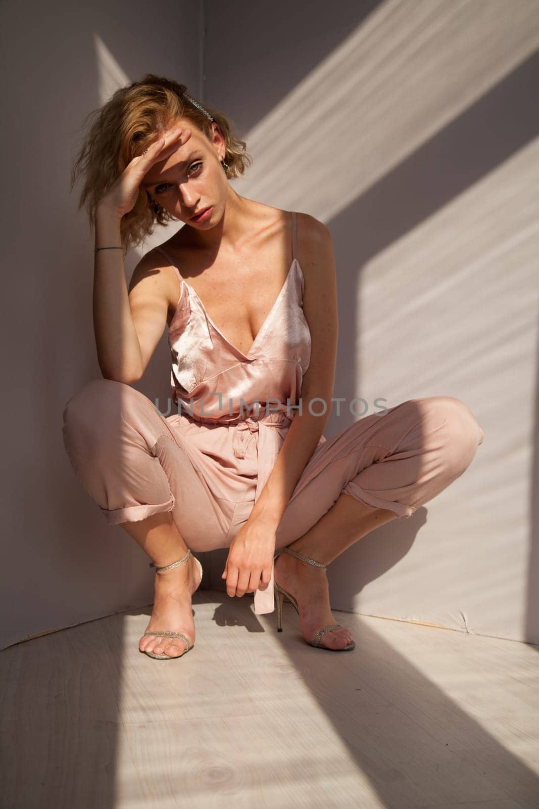 Portrait of a beautiful blonde woman in a pink jumpsuit