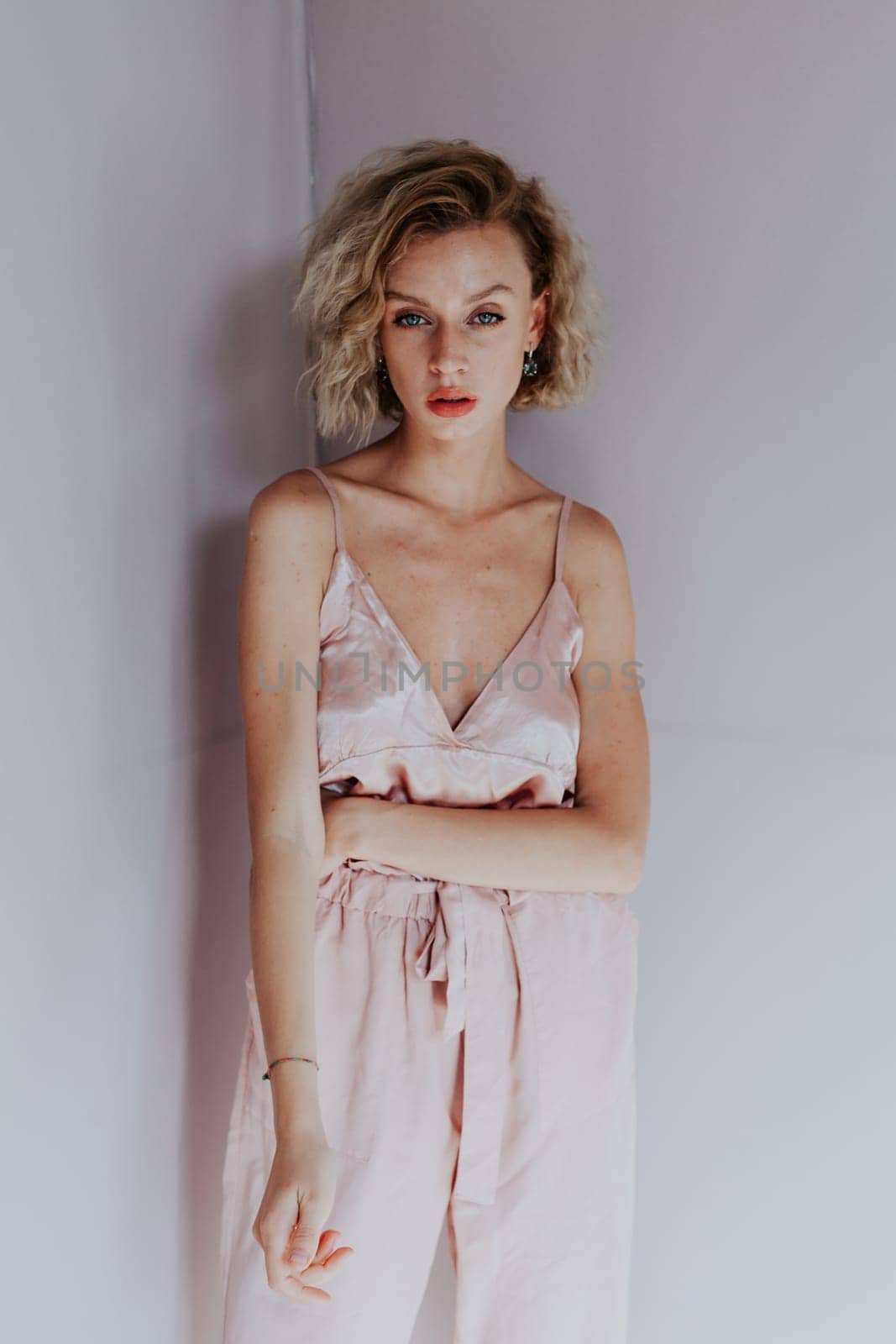 Portrait of a beautiful blonde woman in a pink jumpsuit