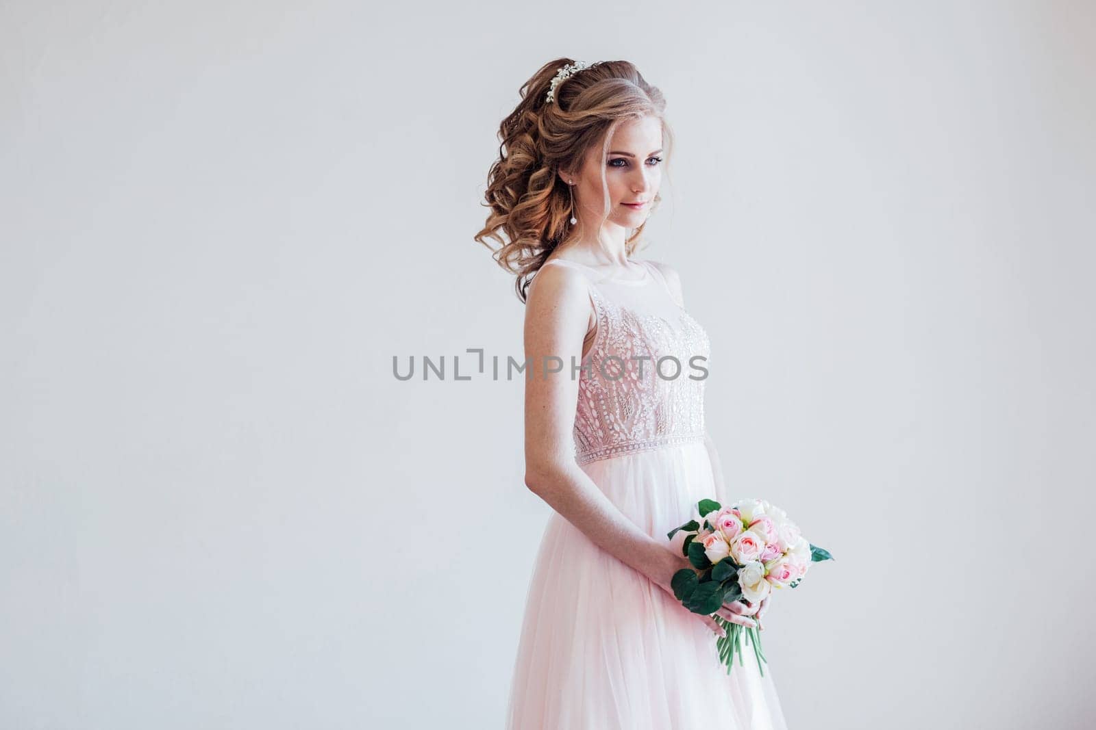 a beautiful bride in a pink wedding dress and bouquet of flowers