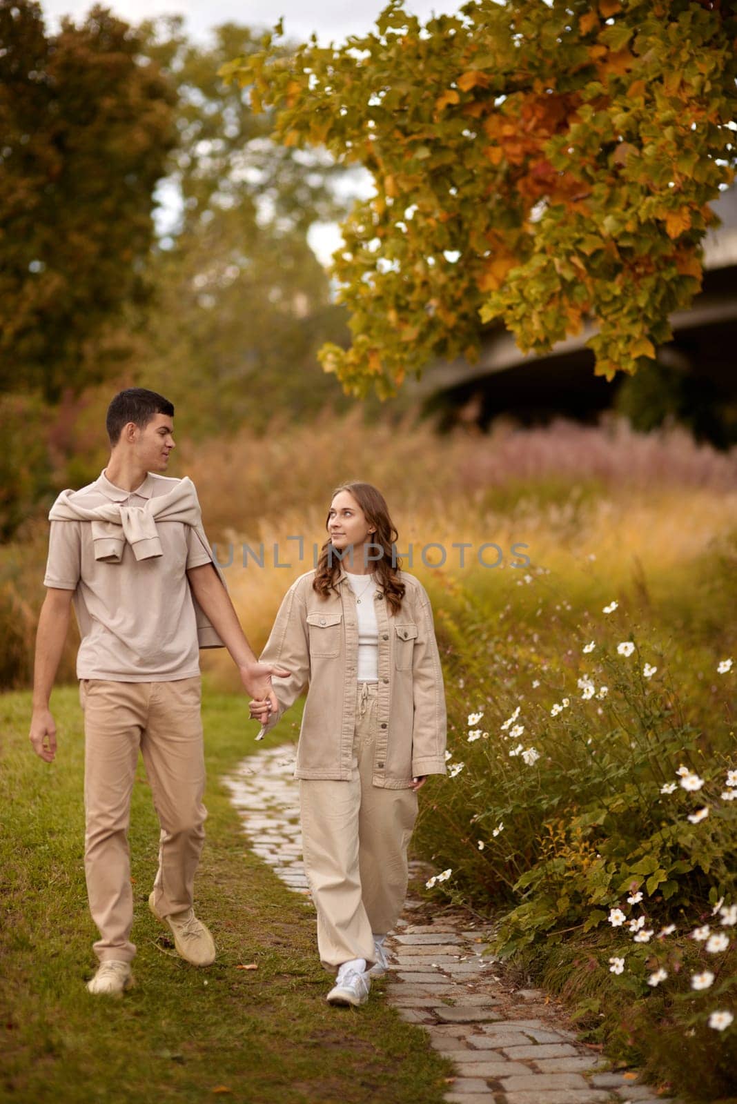 Young Cute Female Hugs Boyfriend. In Autumn Outdoor. Lovers Walking in Park. Attractive Funny Couple. Lovestory in Forest. Man and Woman. Cute Lovers in the Park. Family Concept. Happy Couple.