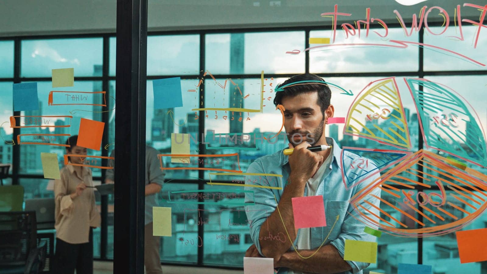 Project manager looking sticky notes at glass wall to planing strategy while multicultural businesspeople discussing, brainstorming idea about business plans at office with city view. Tracery