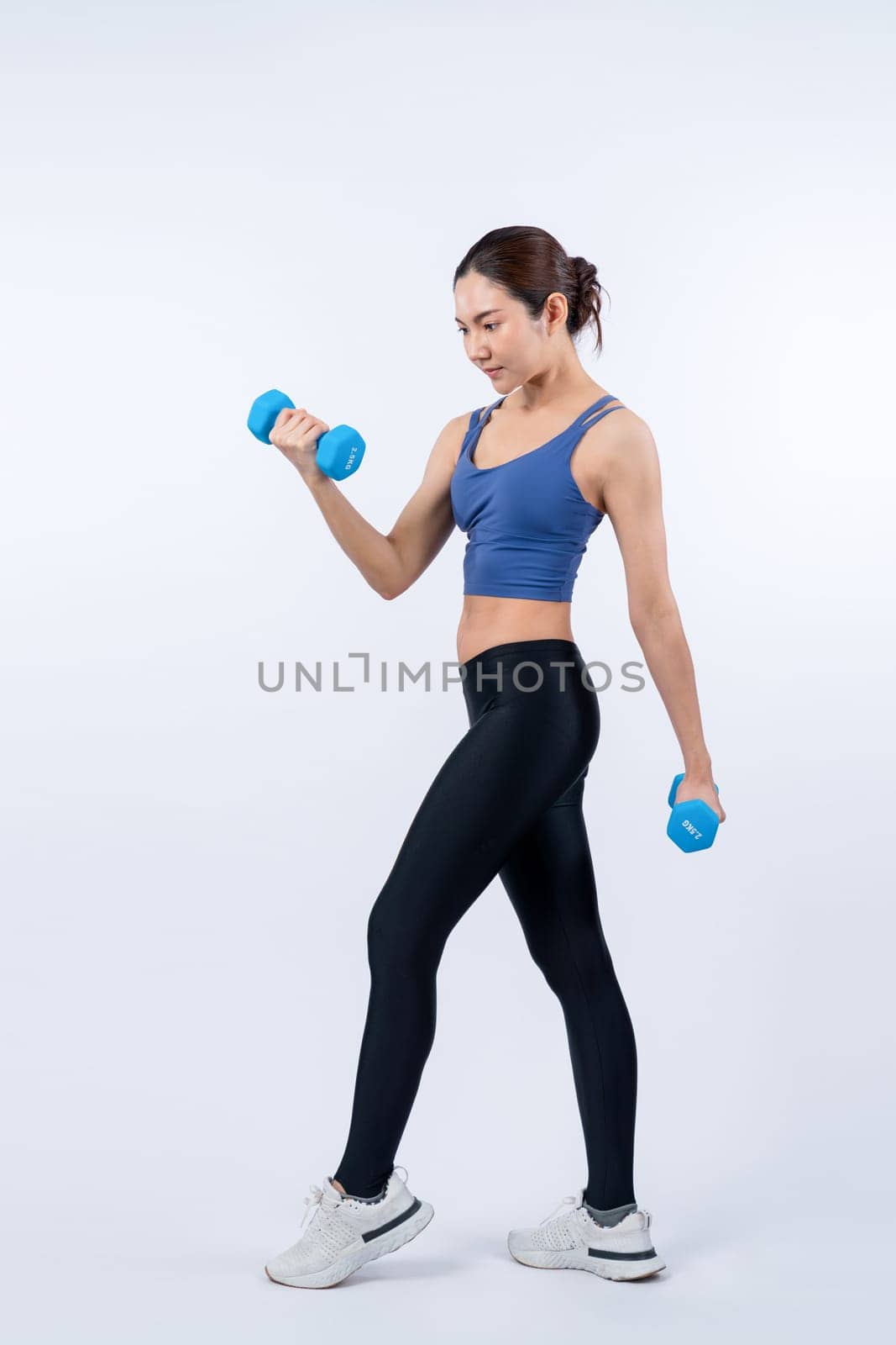Vigorous energetic woman doing yoga with dumbbell weight exercise. by biancoblue