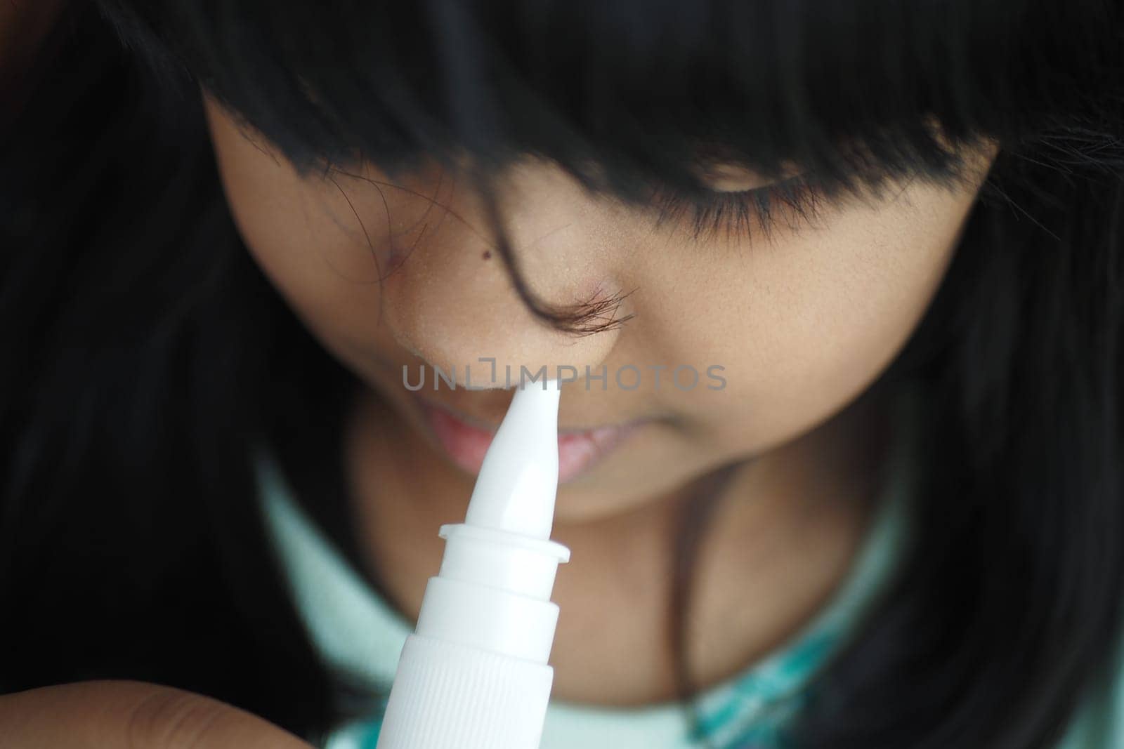 close up of sick child using nasal medicine spray by towfiq007
