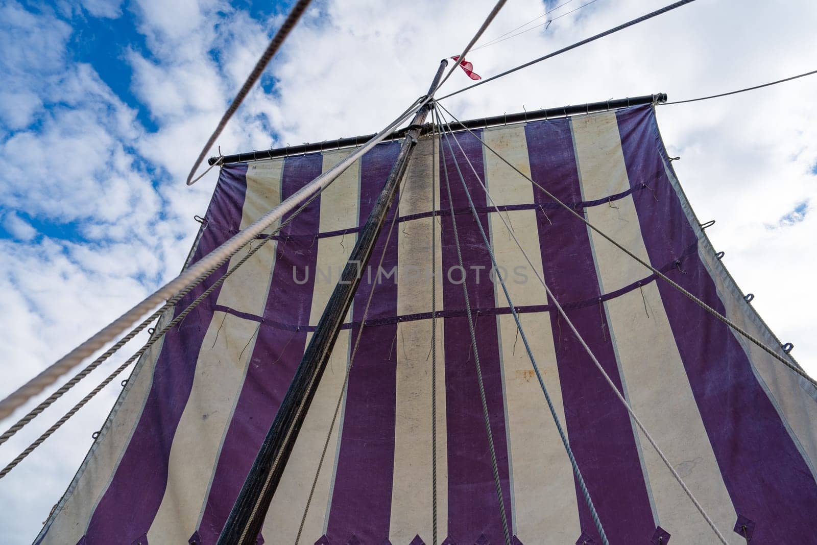 A close-up shot capturing the intricate details of a majestic Viking longship sailing gracefully under clear blue skies, a symbol of ancient maritime adventure and exploration.