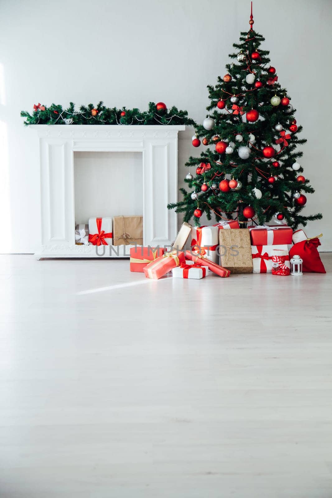 Christmas tree with gifts in the interior of the white room decor for the new year