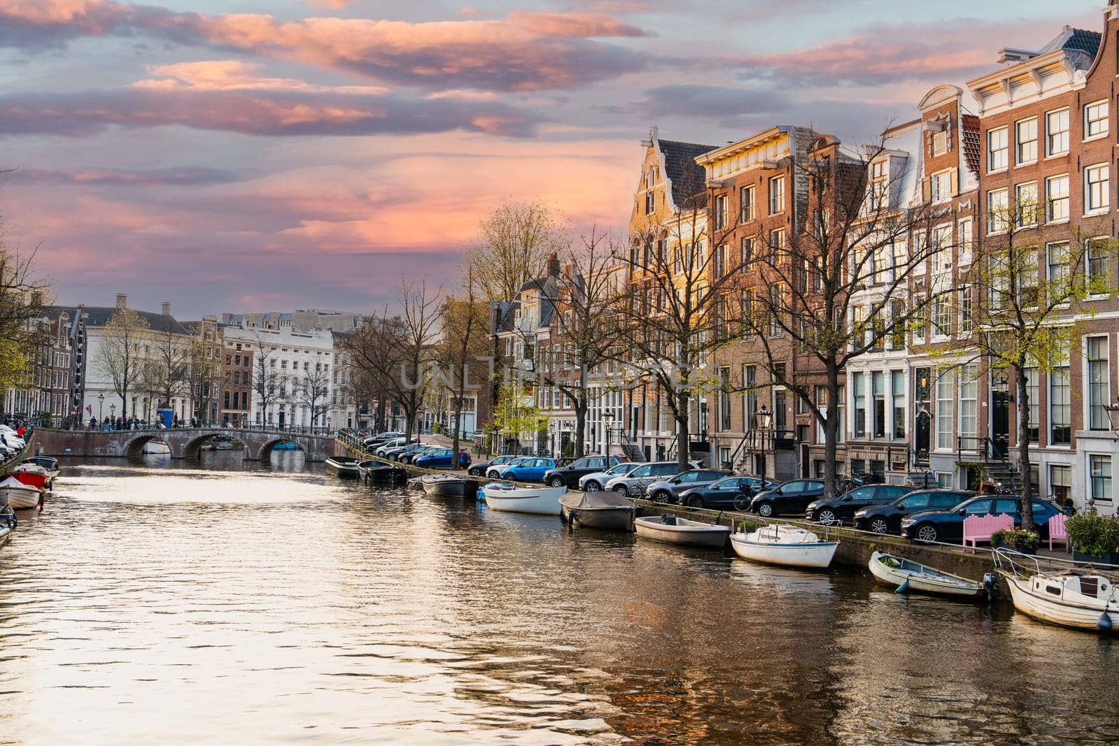 Beautiful view of Amsterdam canals with traditional Dutch houses in the historic district, showcasing the vibrant colors of the buildings reflected in the tranquil water.