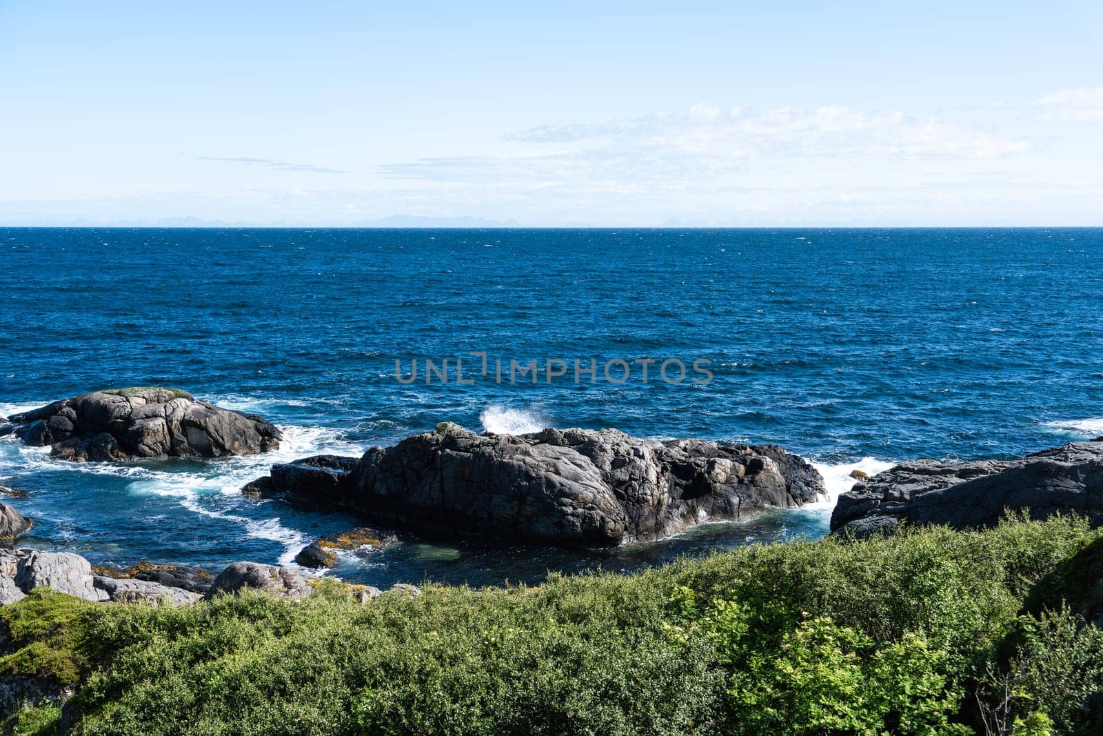 The deep blue Ocean with waves crashing on a rocky island. rugged, rocky coastline at the Sea. Atlantic Ocean coastline with rugged high cliffs. Pacific Ocean rocky coast scenery