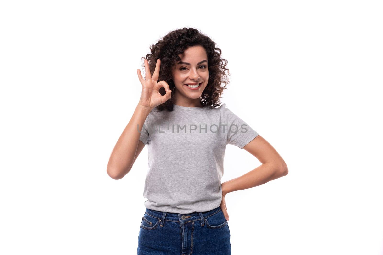 pretty young curly brunette woman in casual t-shirt on white background with copy space.