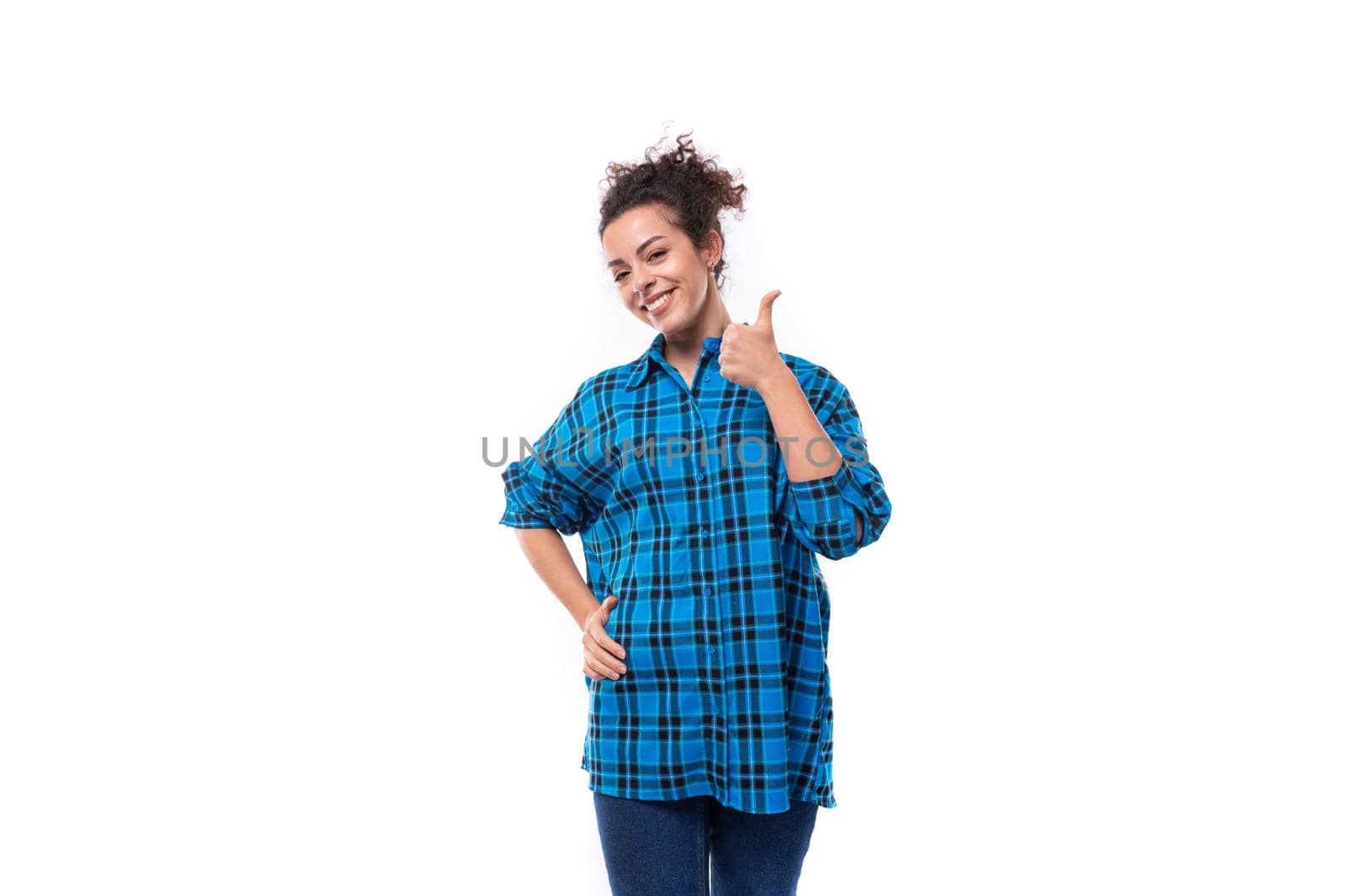 young pretty slender woman with careless curly hairstyle dressed in oversized casual shirt.