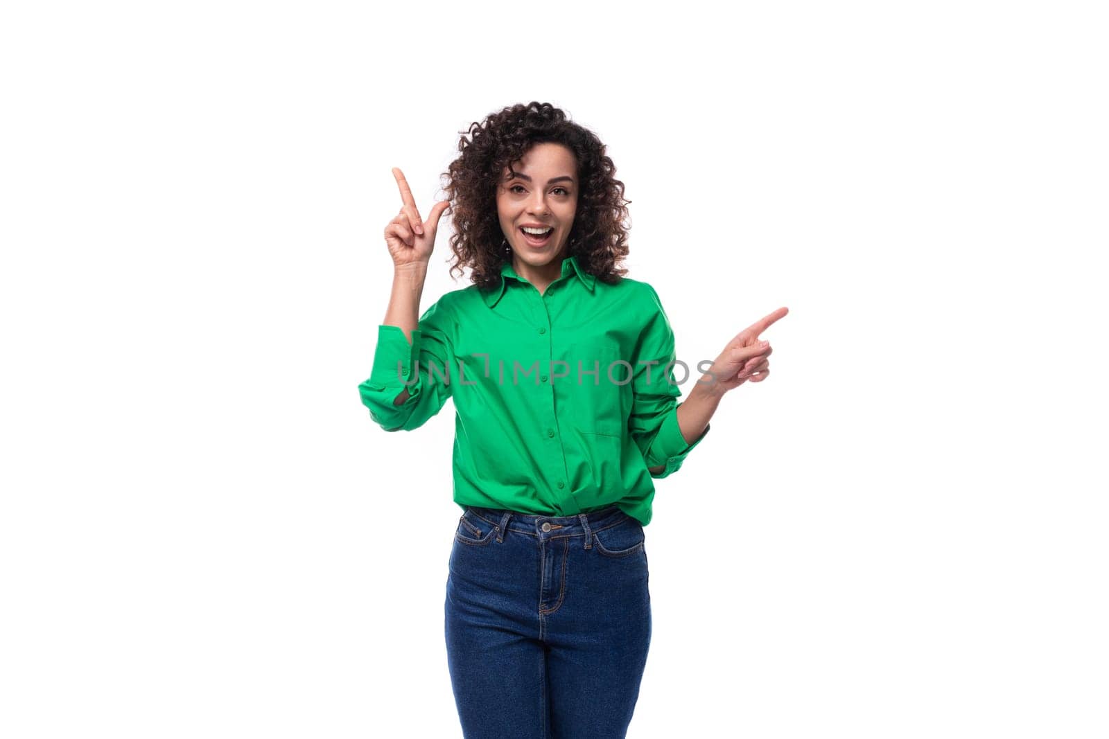 young caucasian brunette woman with curled hair dressed in a green shirt points her finger towards copy space. advertising concept by TRMK