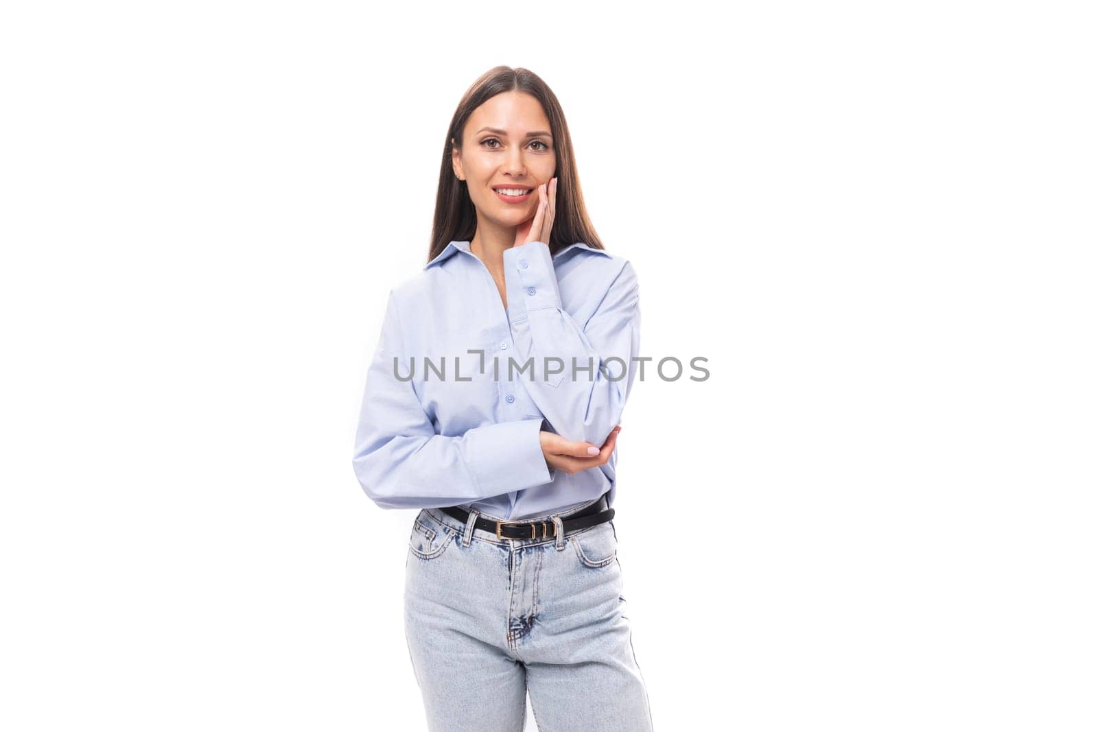 charming young brunette european woman dressed in blue shirt and jeans over isolated background with copy space.
