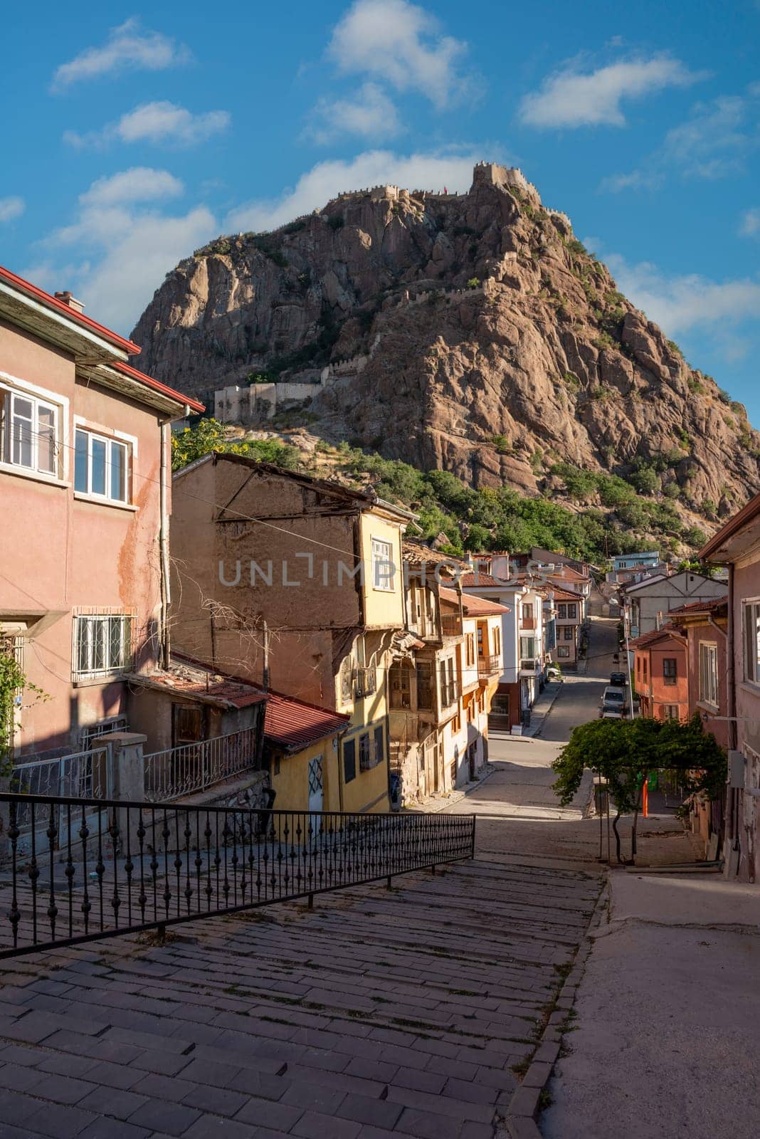 Traditional Turkish Ottoman houses in Afyonkarahisar Turkey. Afyon Castle on the rock and Mevlevihane Museum in front of it