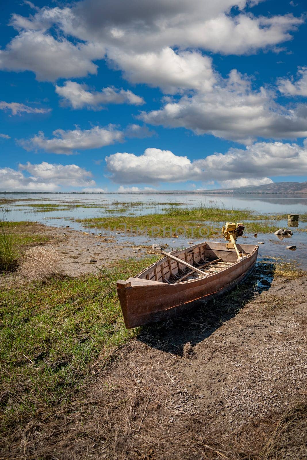 Abandoned row boat on cracked soil on lake bed dried up due to global warming and drought by Sonat