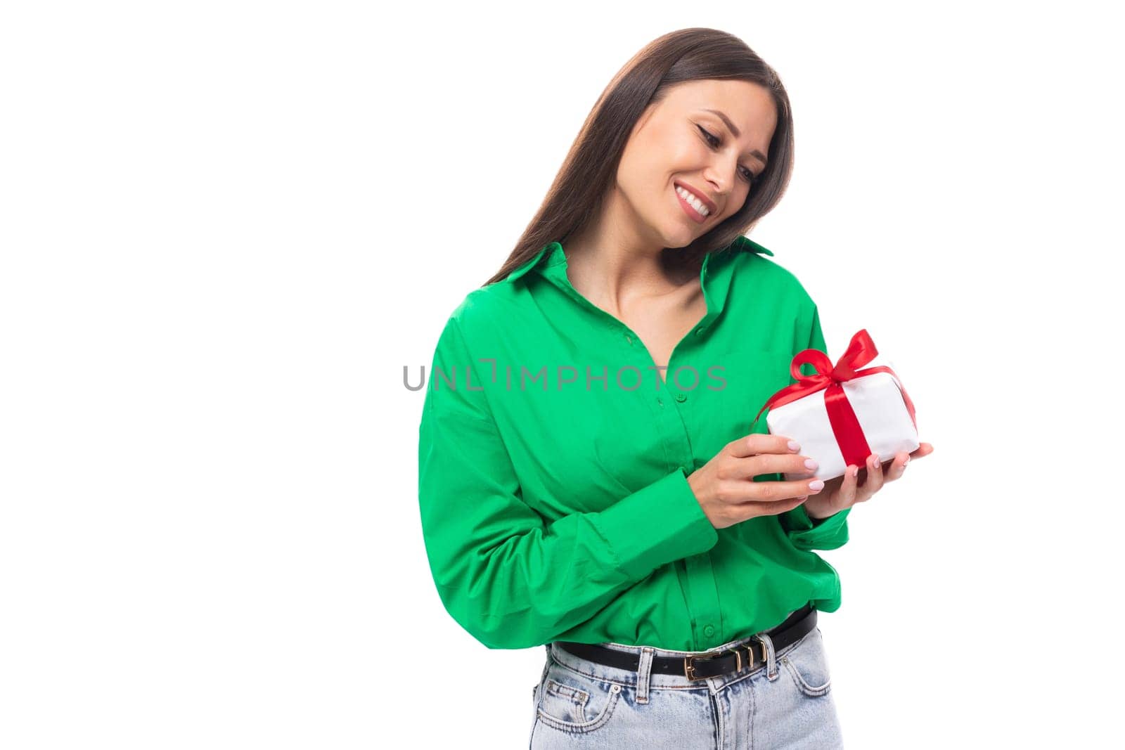 young happy european brunette woman with brown eyes in green blouse holding received a gift from her boyfriend.