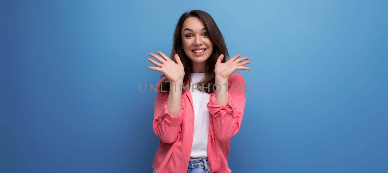 panoramic photo of a long haired brunette young adult in a shirt with cheerful emotions on an isolated background.