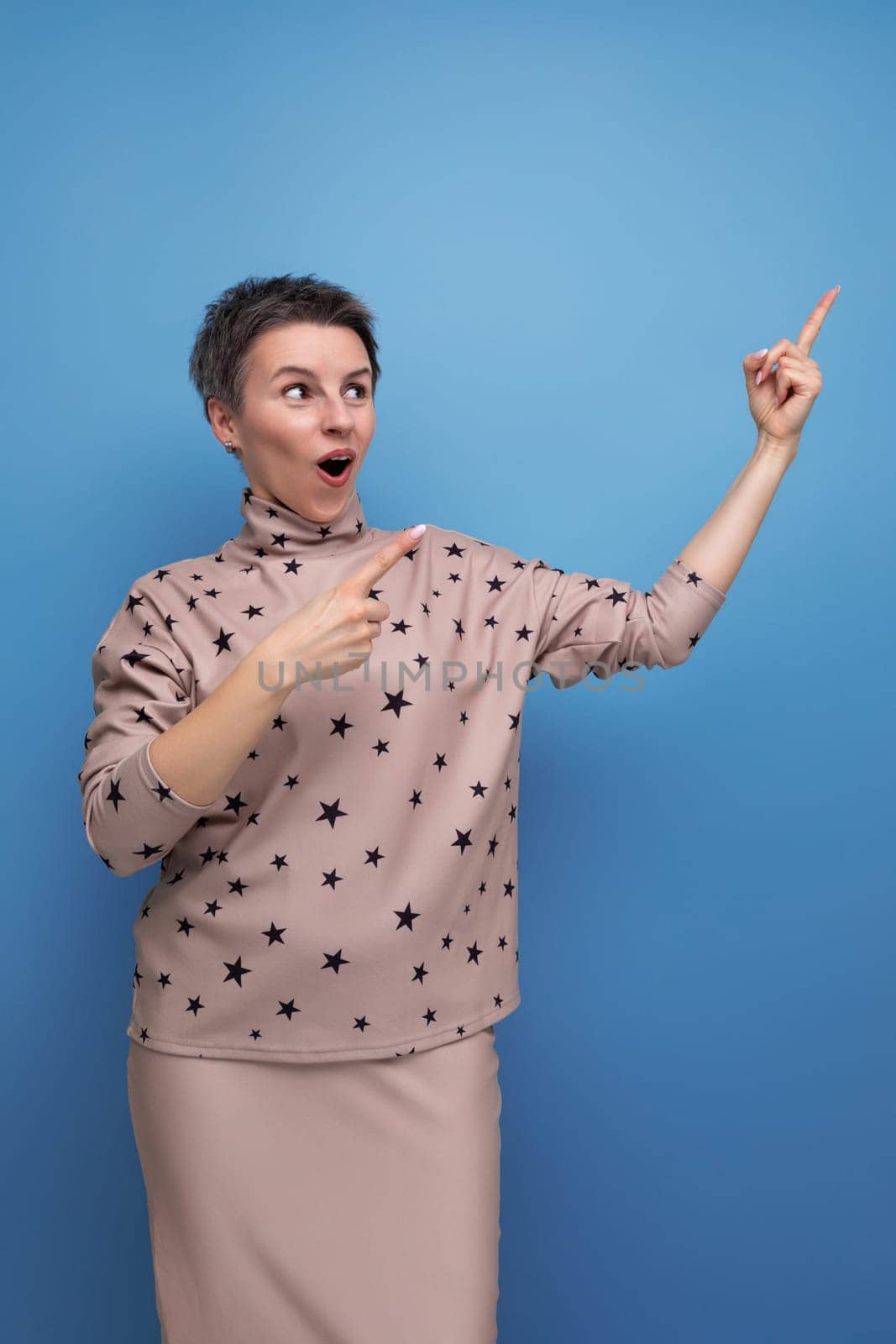 young surprised caucasian woman with short gray hair is dressed in a suit of skirt and blouse.