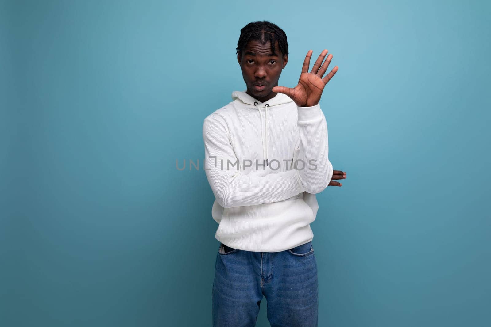 charismatic american man in white hoodie on blue background.