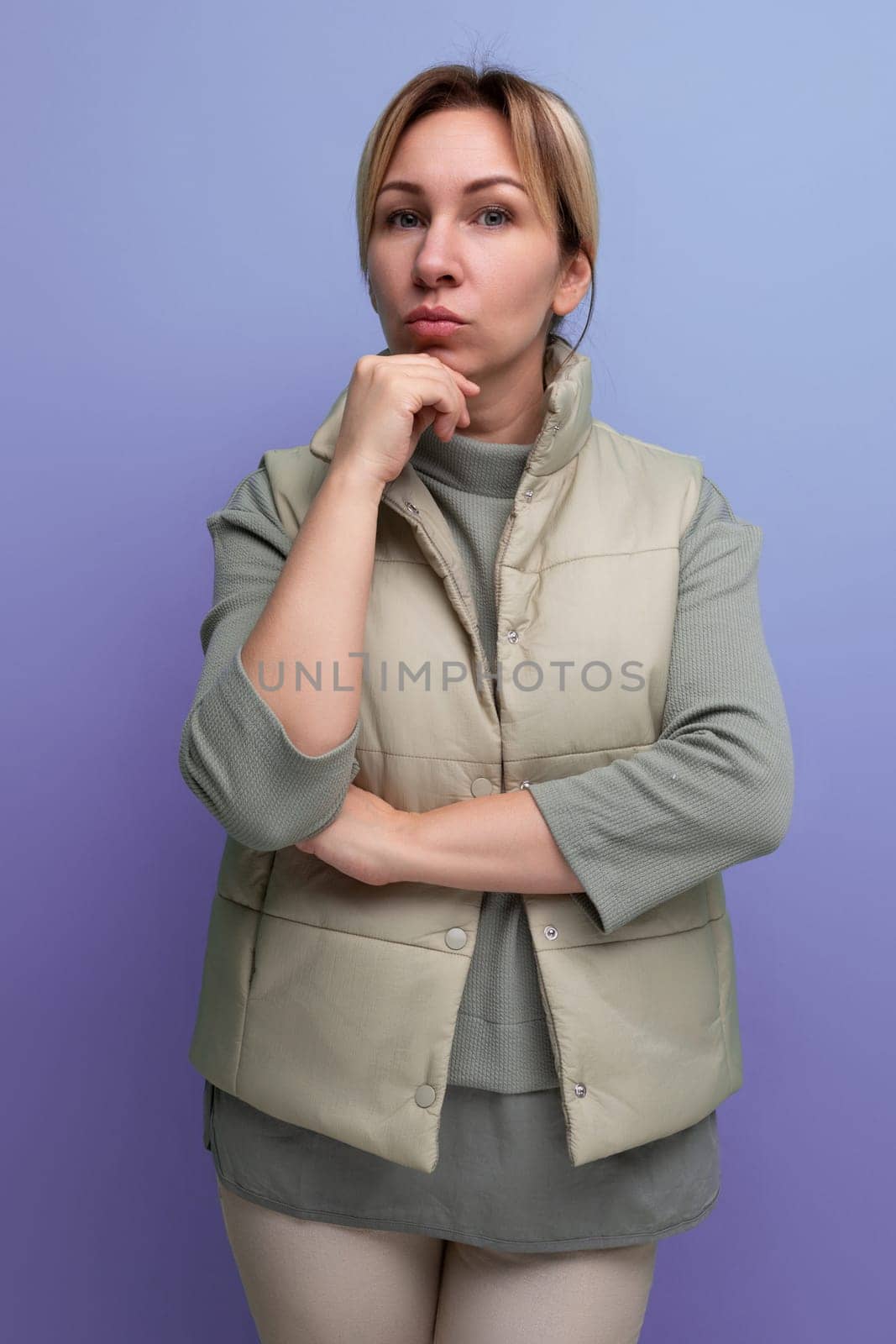 serious pensive blond young woman in spring stylish look on studio background.