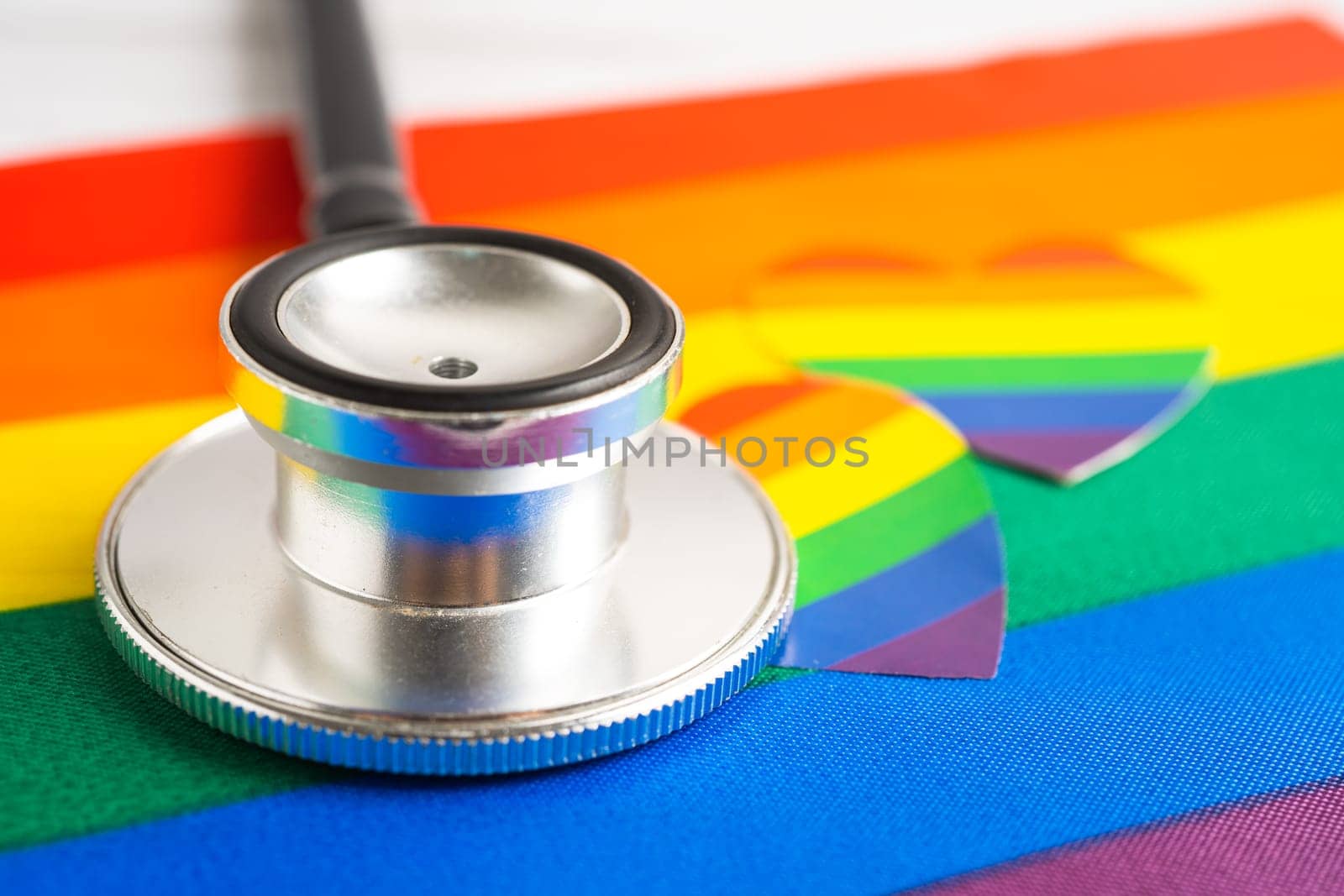 Black stethoscope on rainbow flag with heart, symbol of LGBT pride month celebrate annual in June social, symbol of gay, lesbian, bisexual, transgender, human rights and peace. by pamai