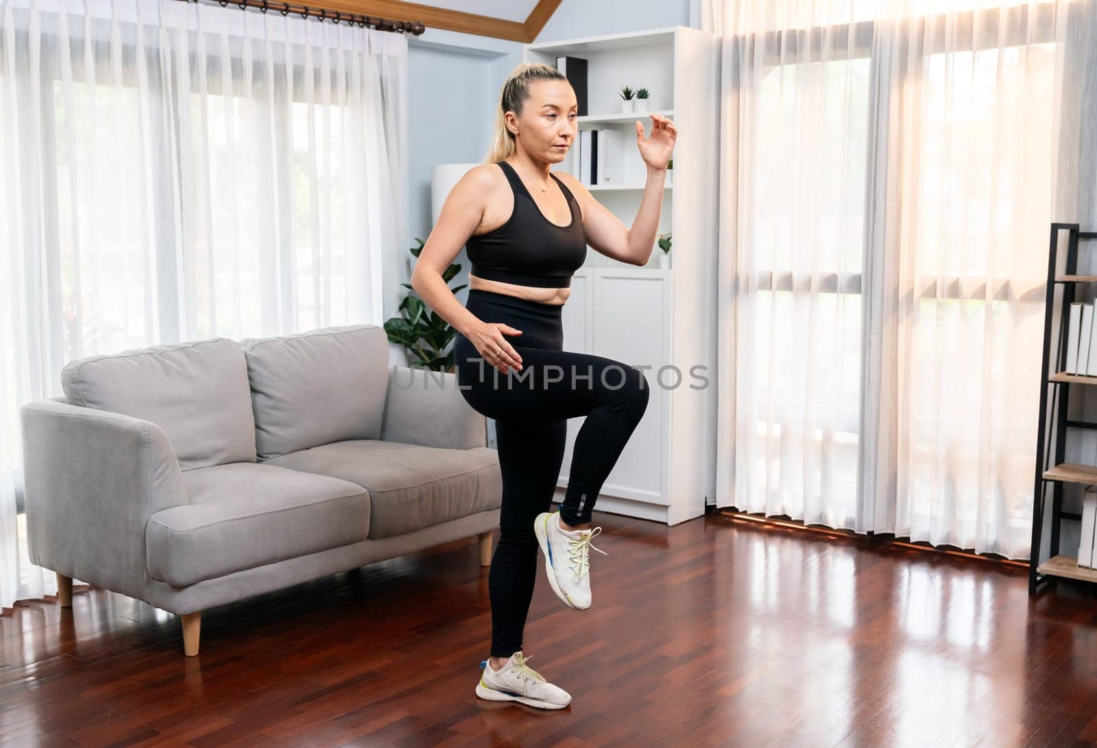 Athletic and sporty senior woman make running pose at home. Clout by biancoblue