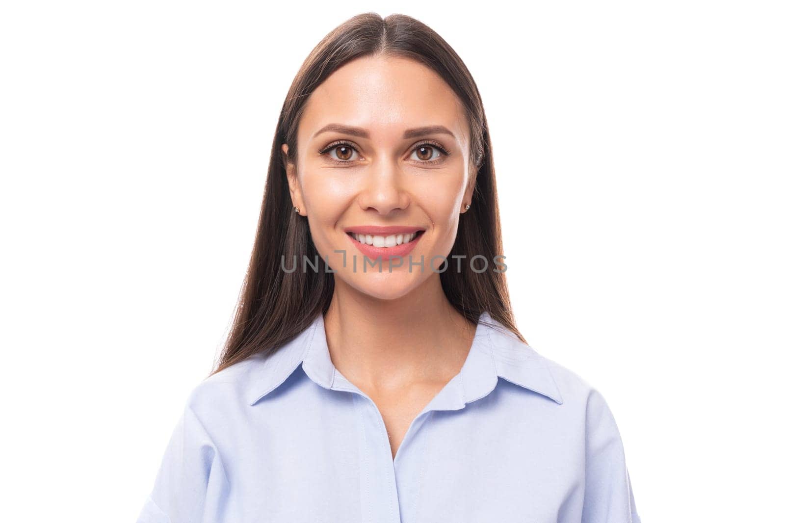 portrait of a young charming european business woman with long black hair dressed in a blue blouse on a white background with copy space.