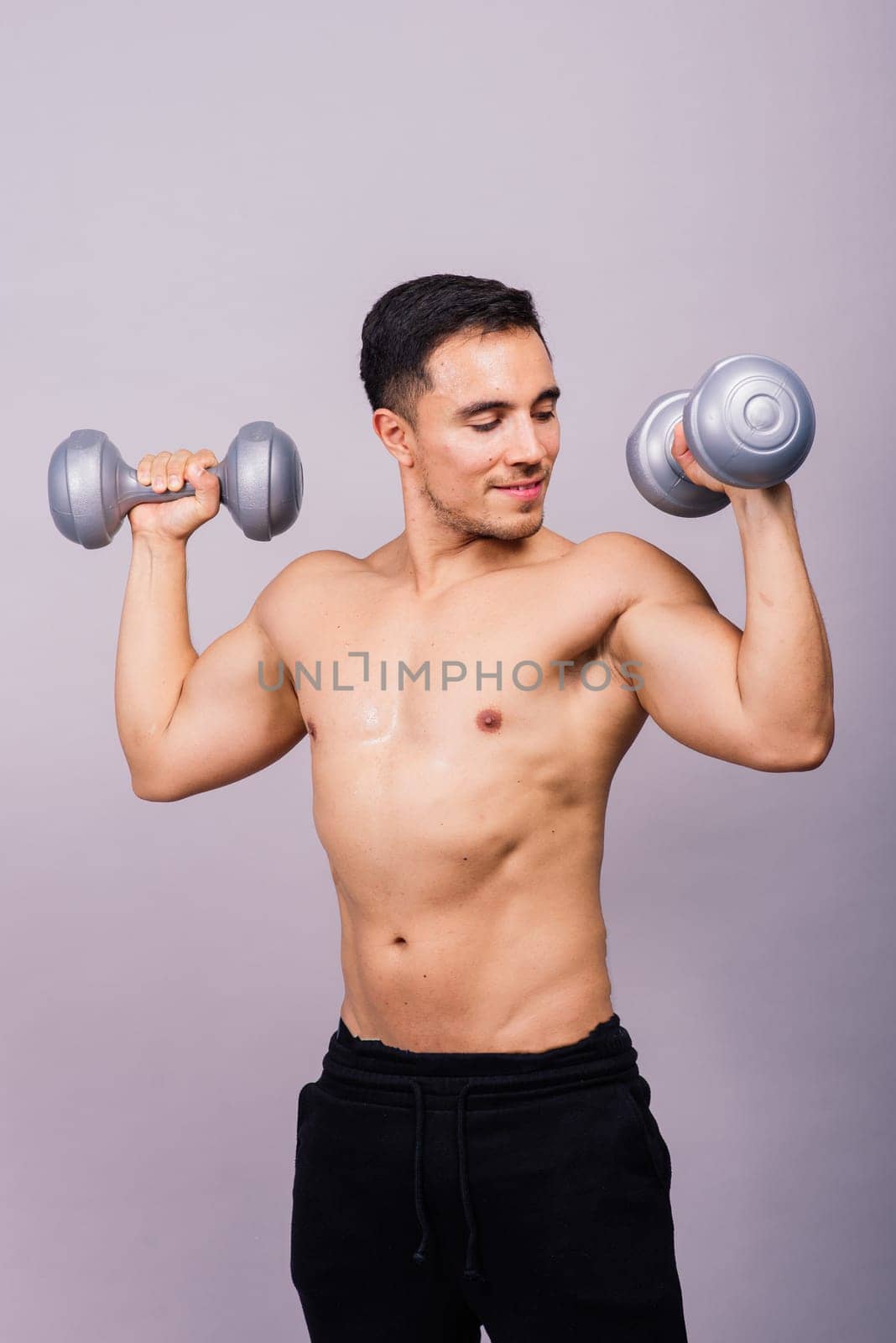 Shirtless bodybuilder showing his great body and holding dumbell. by Zelenin