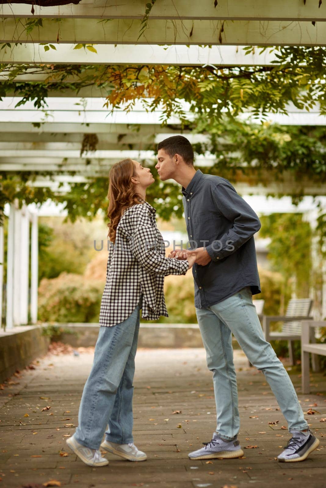 Warm Embrace of Teen Love in the Autumn Park. Capturing Teen Moments: Love Blossoms in Autumn's Embrace. Teenagers in Love: Embracing the Autumn Vibe by Andrii_Ko