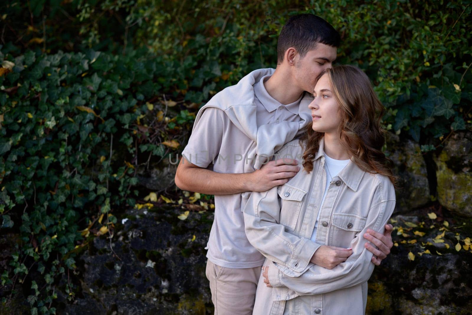 Warm Embrace of Teen Love in the Autumn Park. Capturing Teen Moments: Love Blossoms in Autumn's Embrace. Teenagers in Love: Embracing the Autumn Vibe by Andrii_Ko