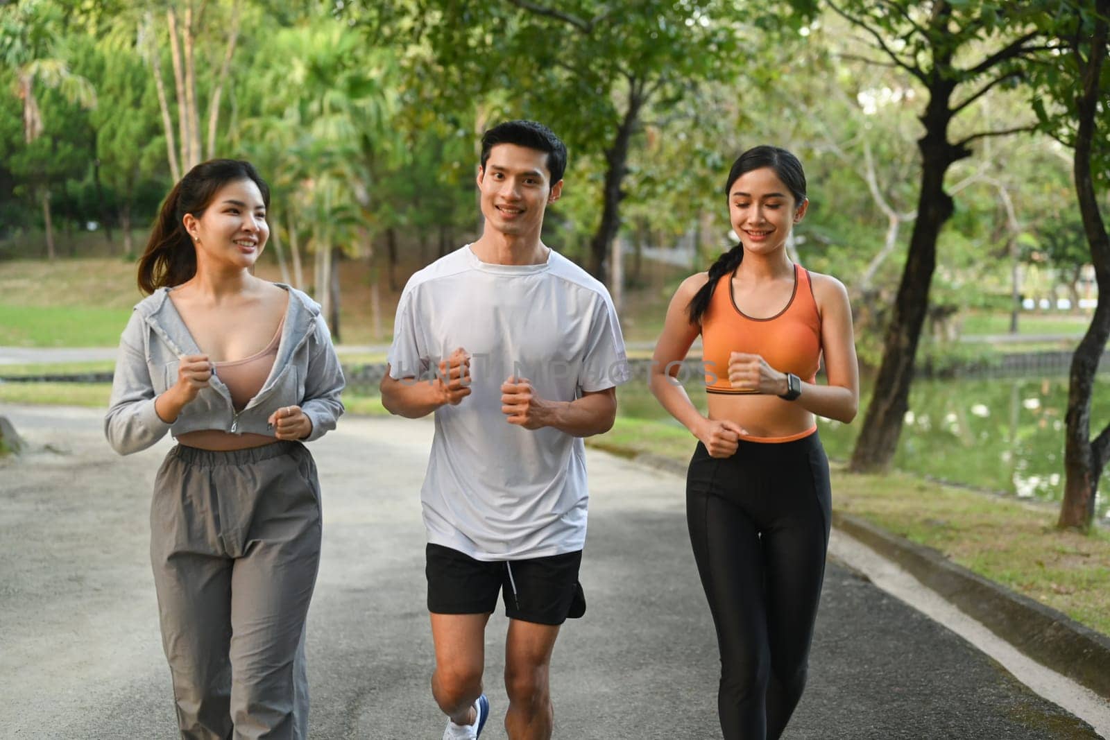 Group of young people in sports clothing jogging in the city park. Healthy Lifestyle concept.
