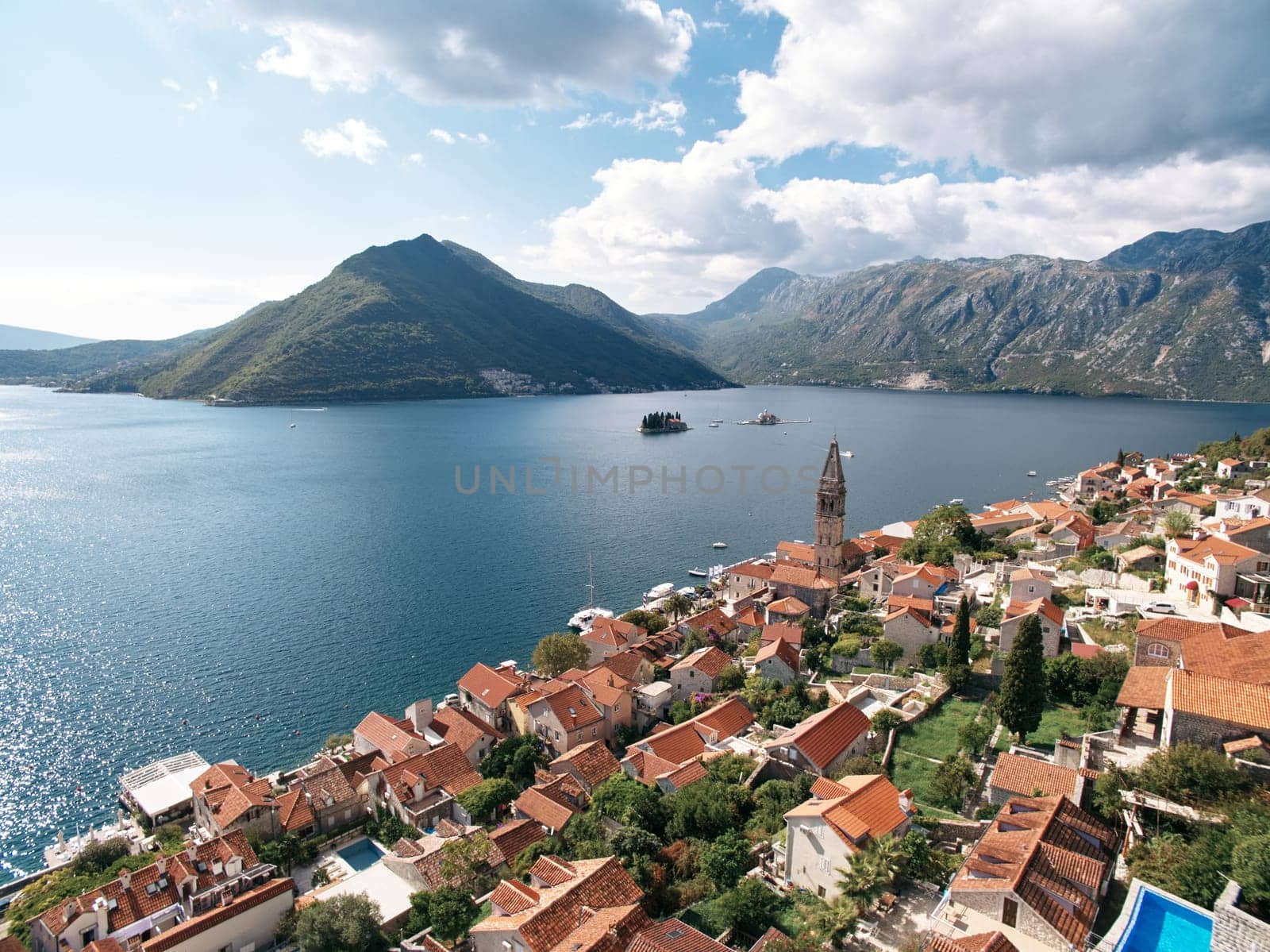 View of the islands in the Bay of Kotor over the red roofs of old houses. Perast, Montenegro. Drone. High quality photo
