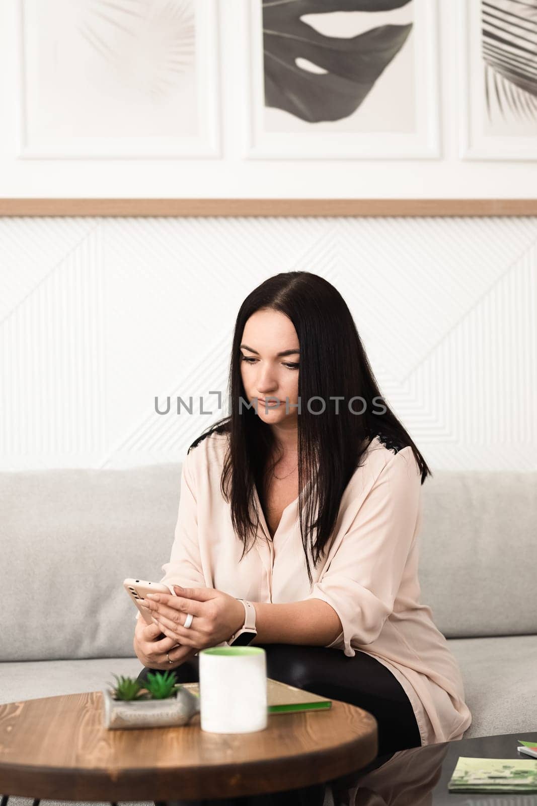 A girl in the office is texting on her smartphone by Mastak80