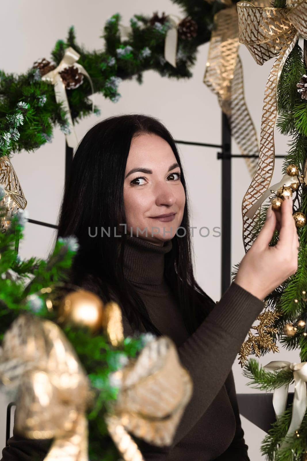 A brunette girl stands next to Christmas decorations in the office at work