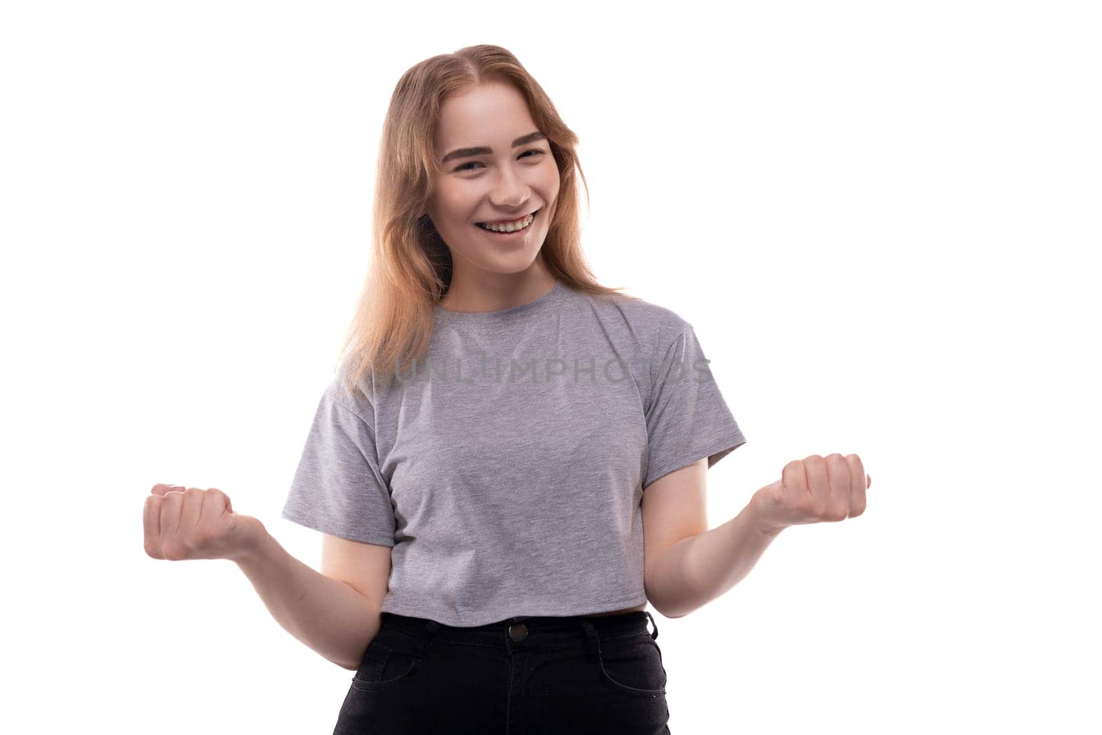 Portrait of a charming teenage girl with braces in a gray T-shirt on a white background by TRMK