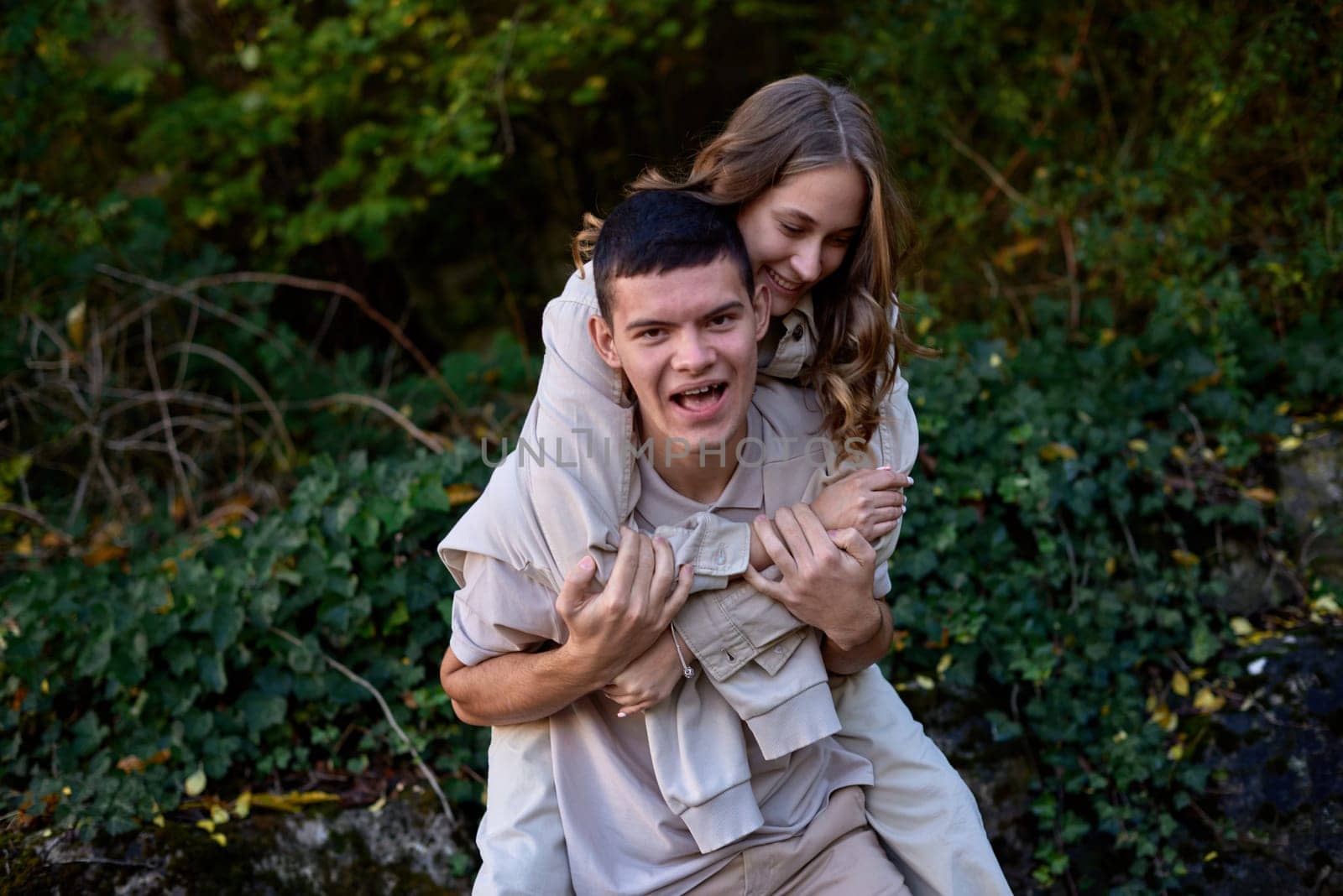 Young Cute Female Hugs Boyfriend. In Autumn Outdoor. Lovers Walking in Park. Attractive Funny Couple. Lovestory in Forest. Man and Woman. Cute Lovers in the Park. Family Concept. Happy Couple.