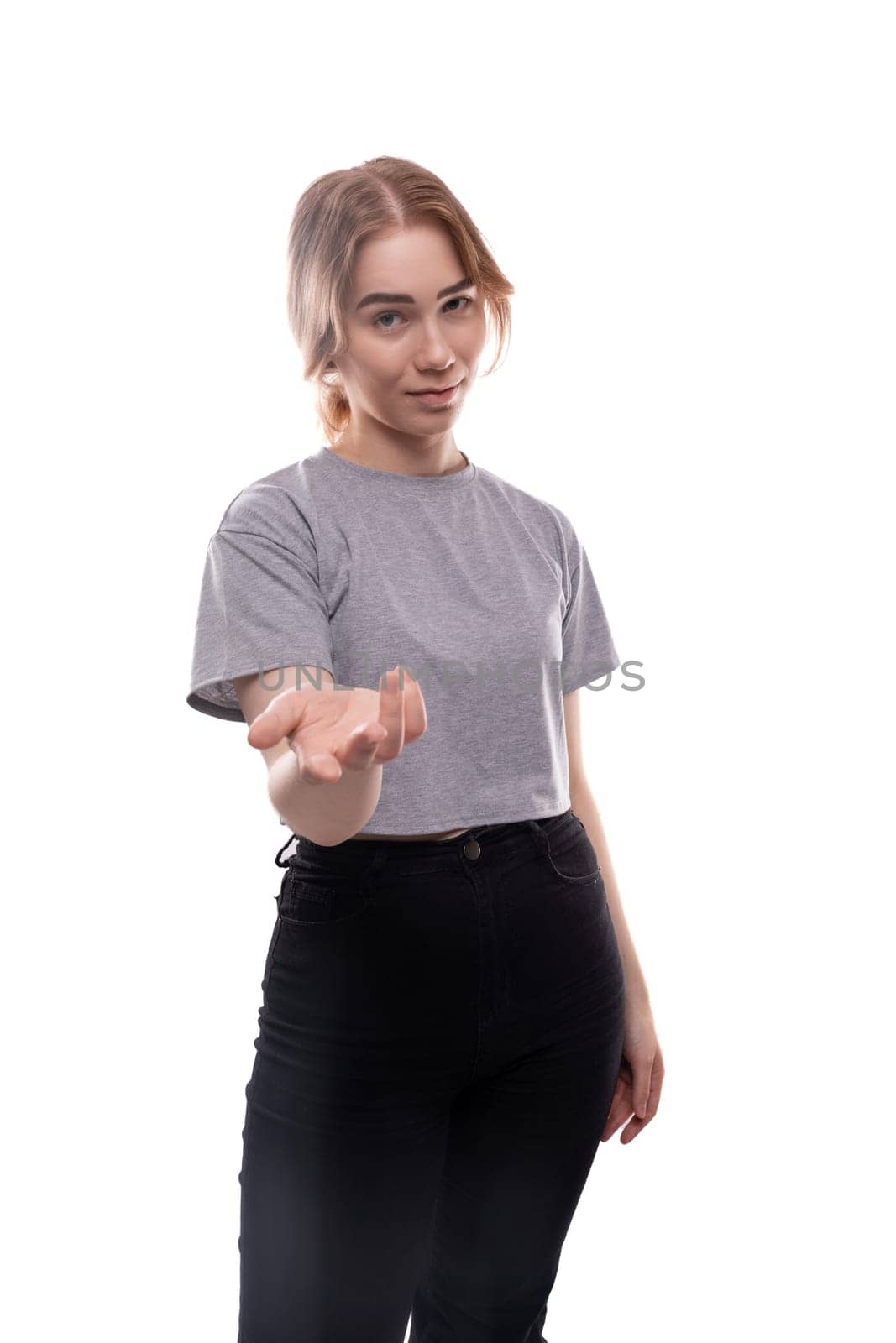 Confused fair-haired teenage girl in a gray T-shirt doubts.