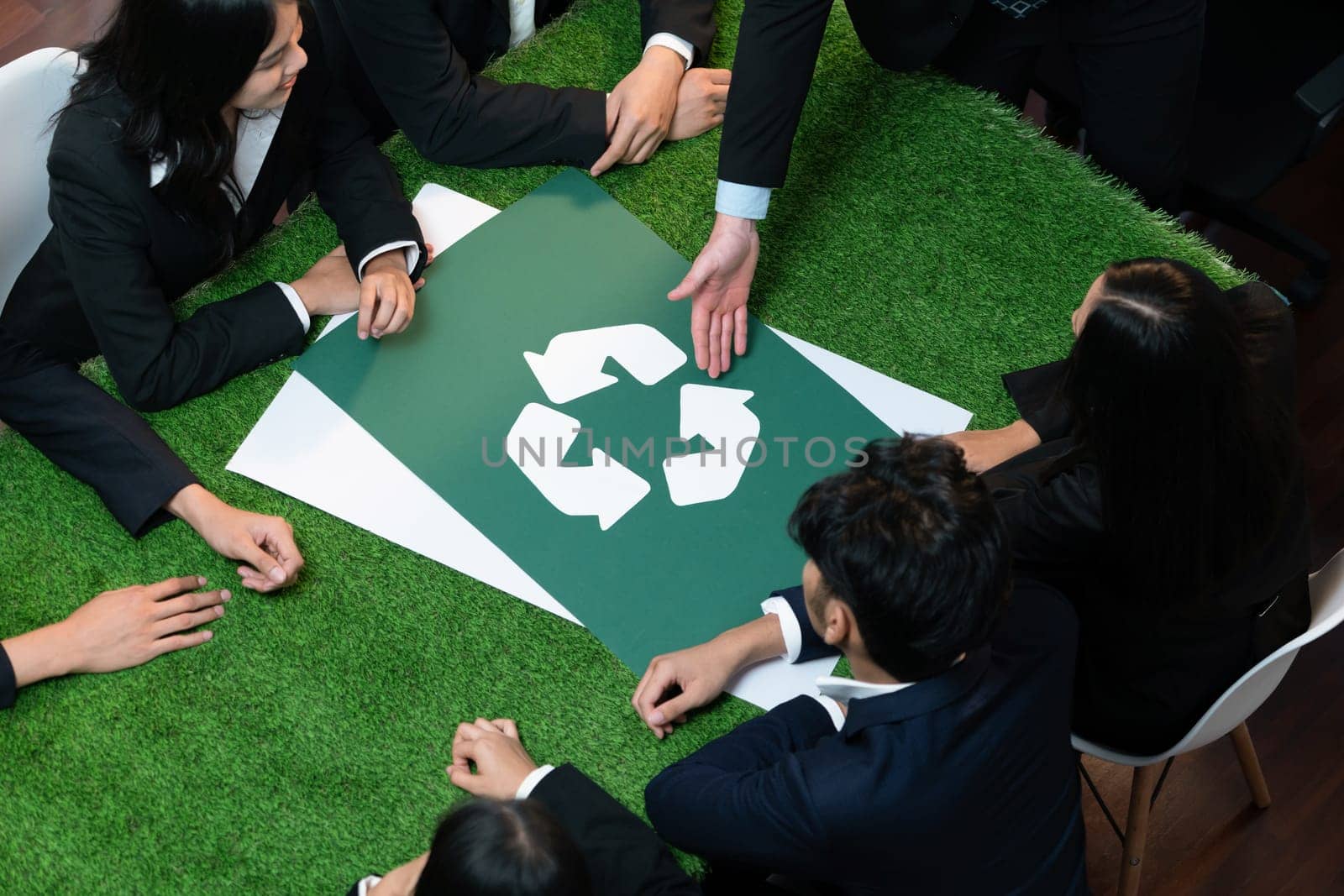 Recycle icon on meeting table with business people. Quaint by biancoblue